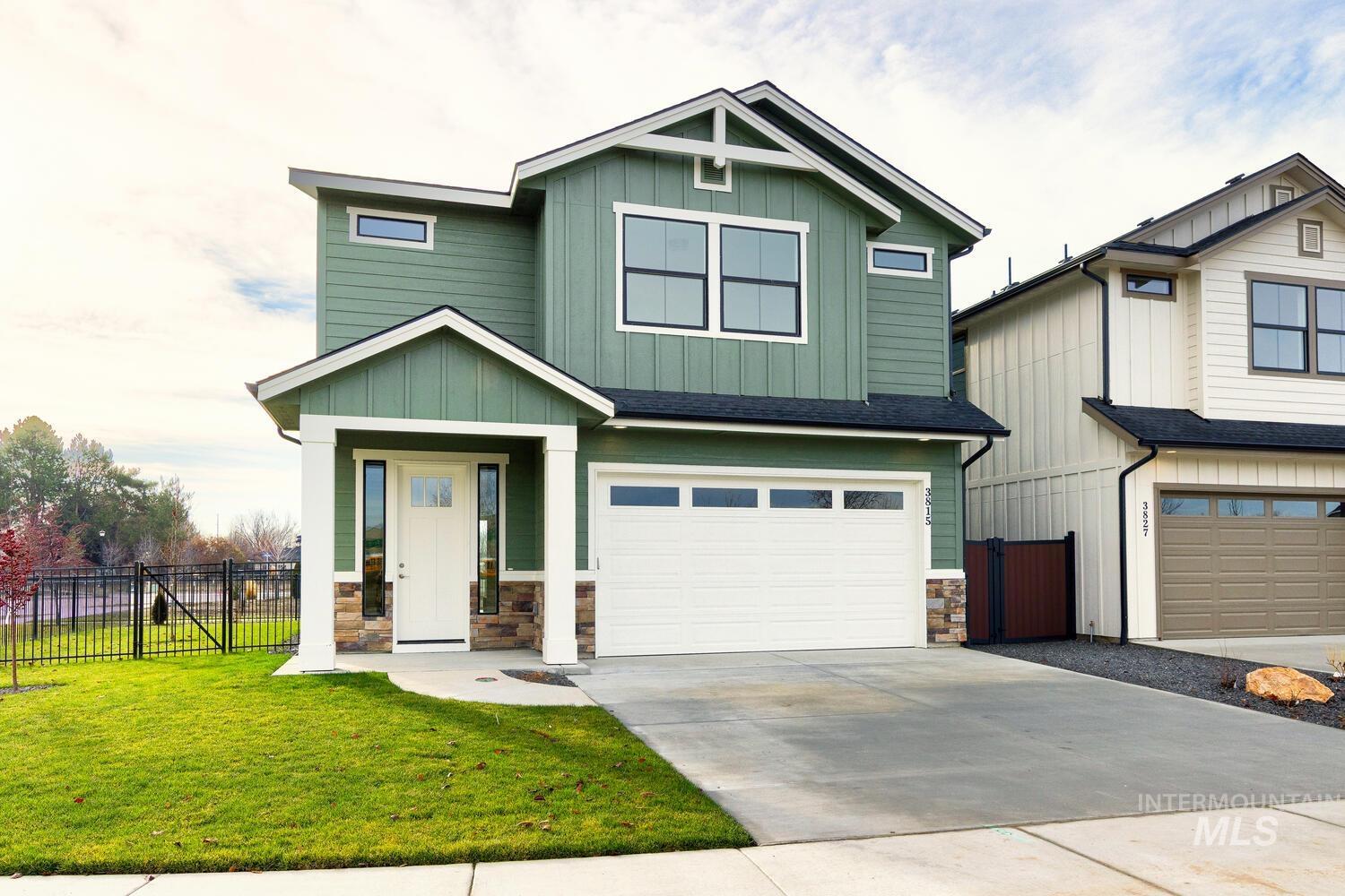 Craftsman house with board and batten siding, a garage, stone siding, driveway, and roof with shingles
