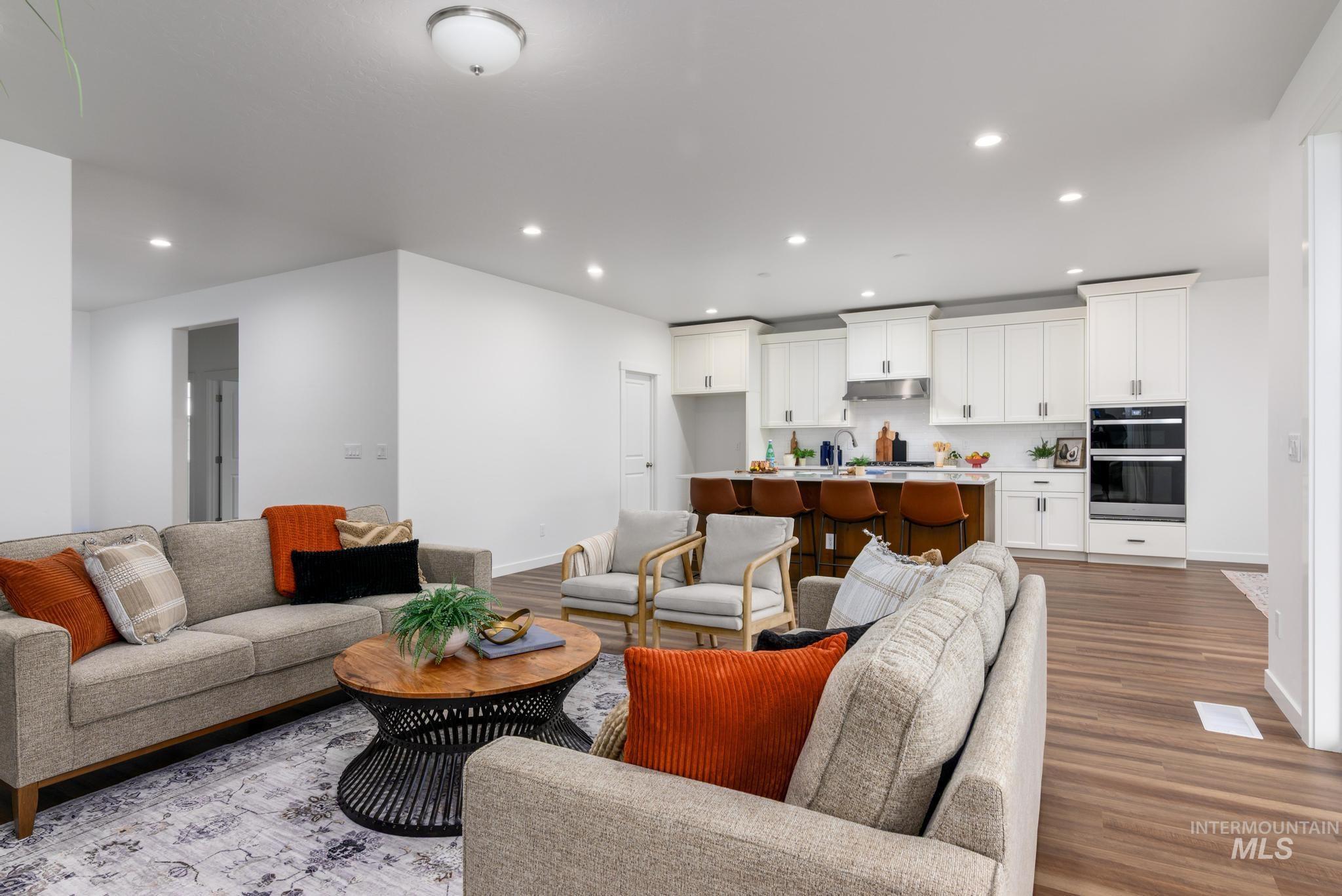 Living room with recessed lighting and dark wood-type flooring