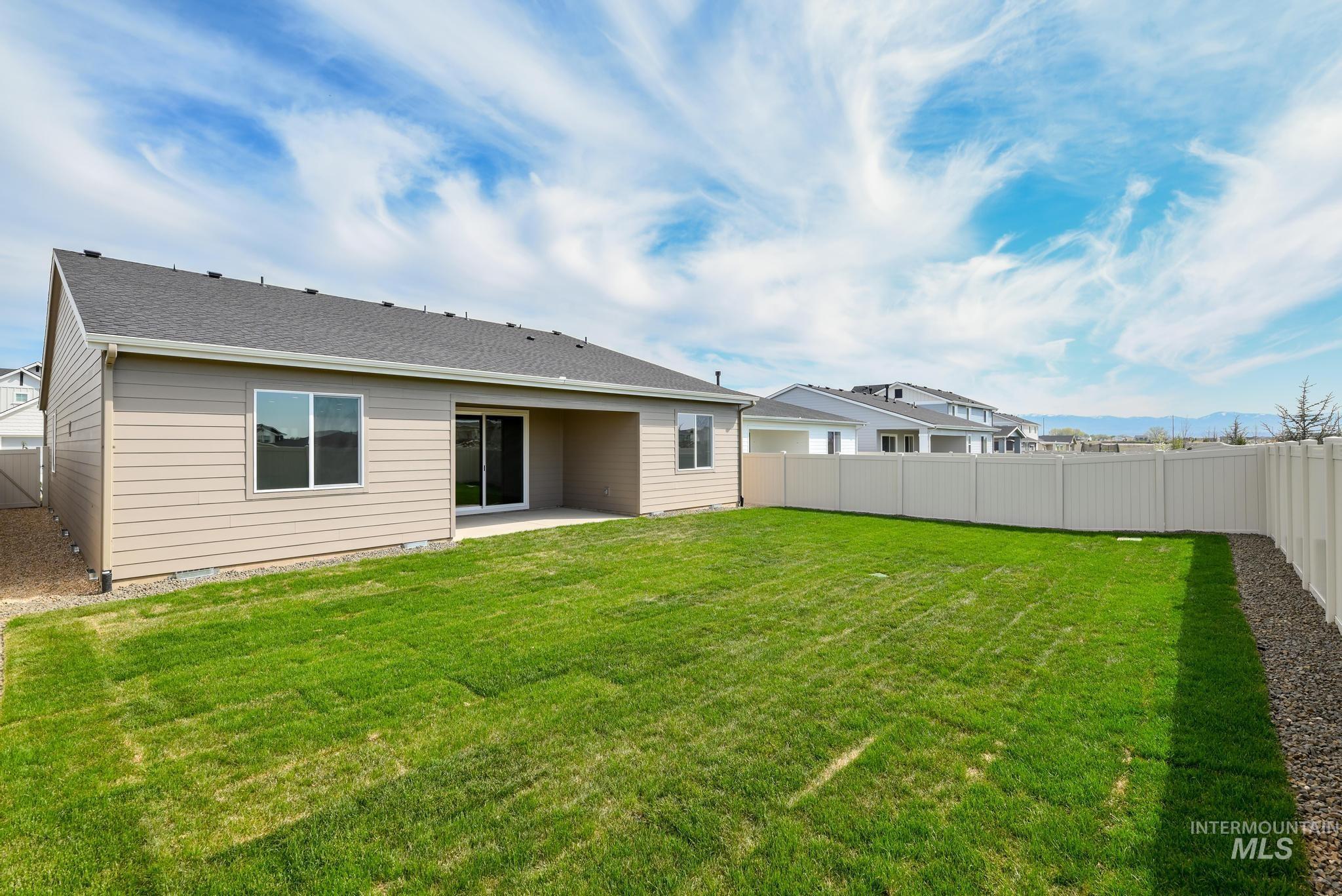 Rear view of property with a patio area, a fenced backyard, and roof with shingles