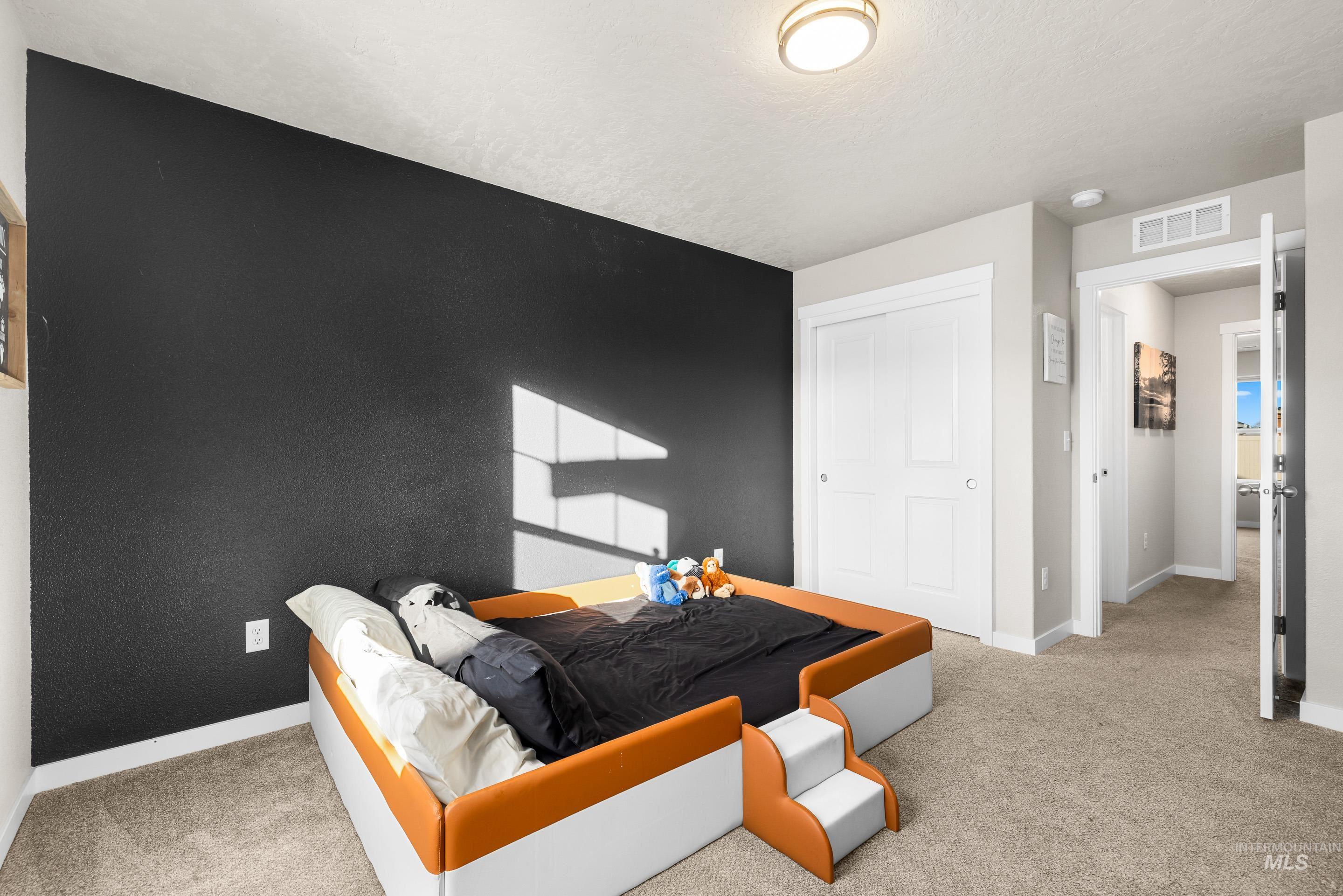 Bedroom with light carpet and a closet