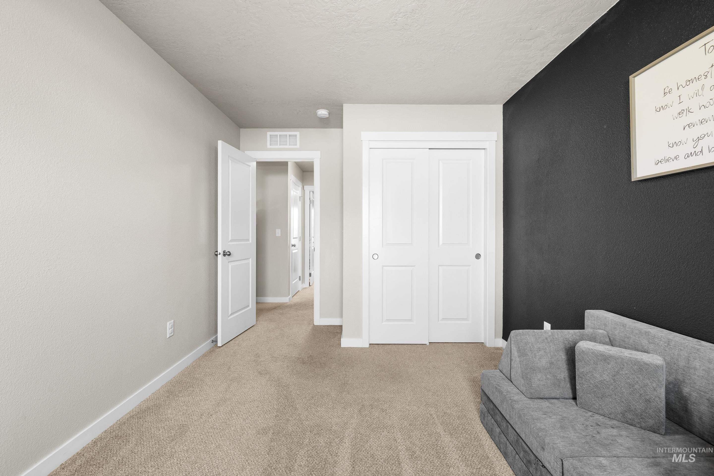 Living area featuring light carpet and a textured ceiling