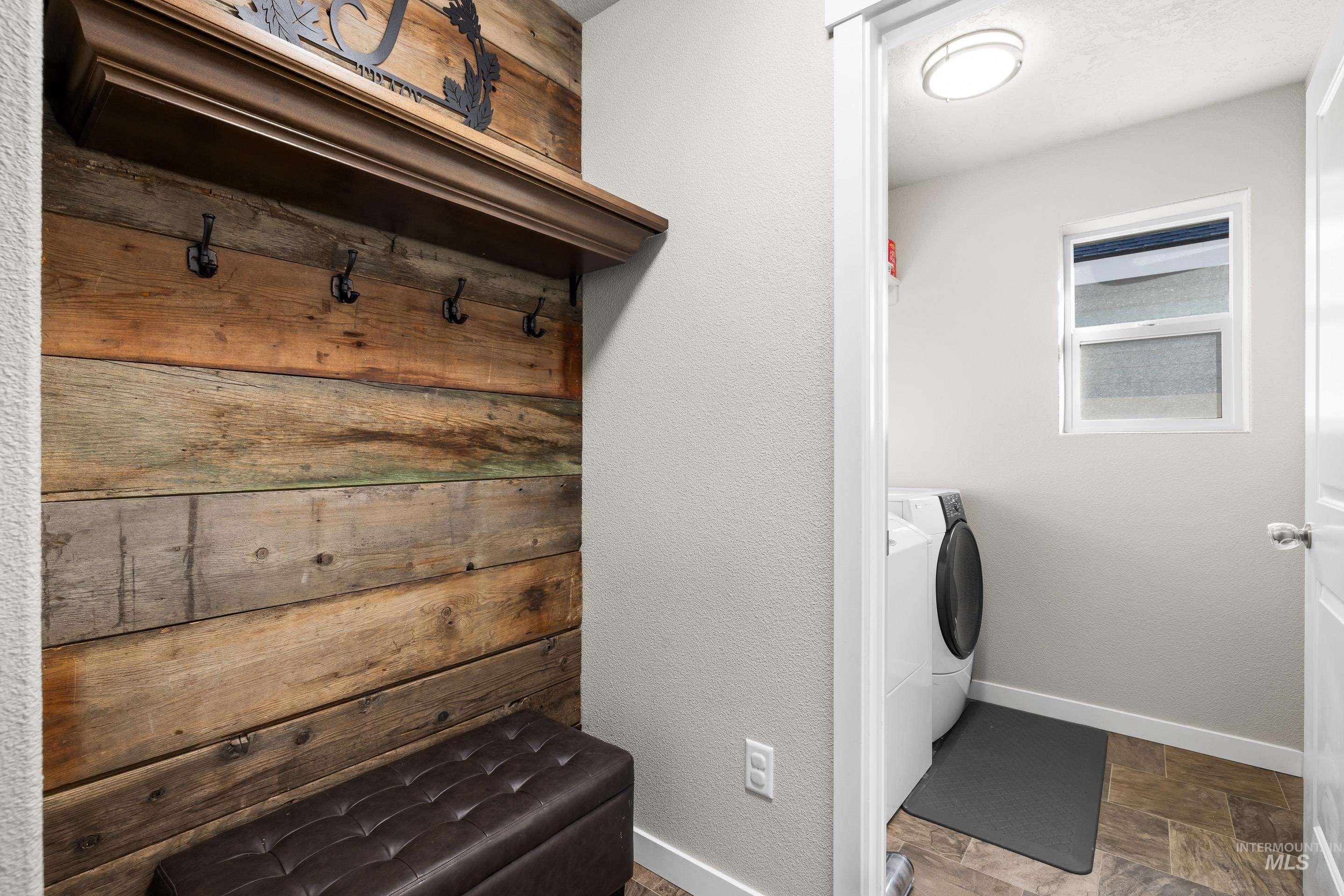 Laundry area featuring stone finish flooring and separate washer and dryer