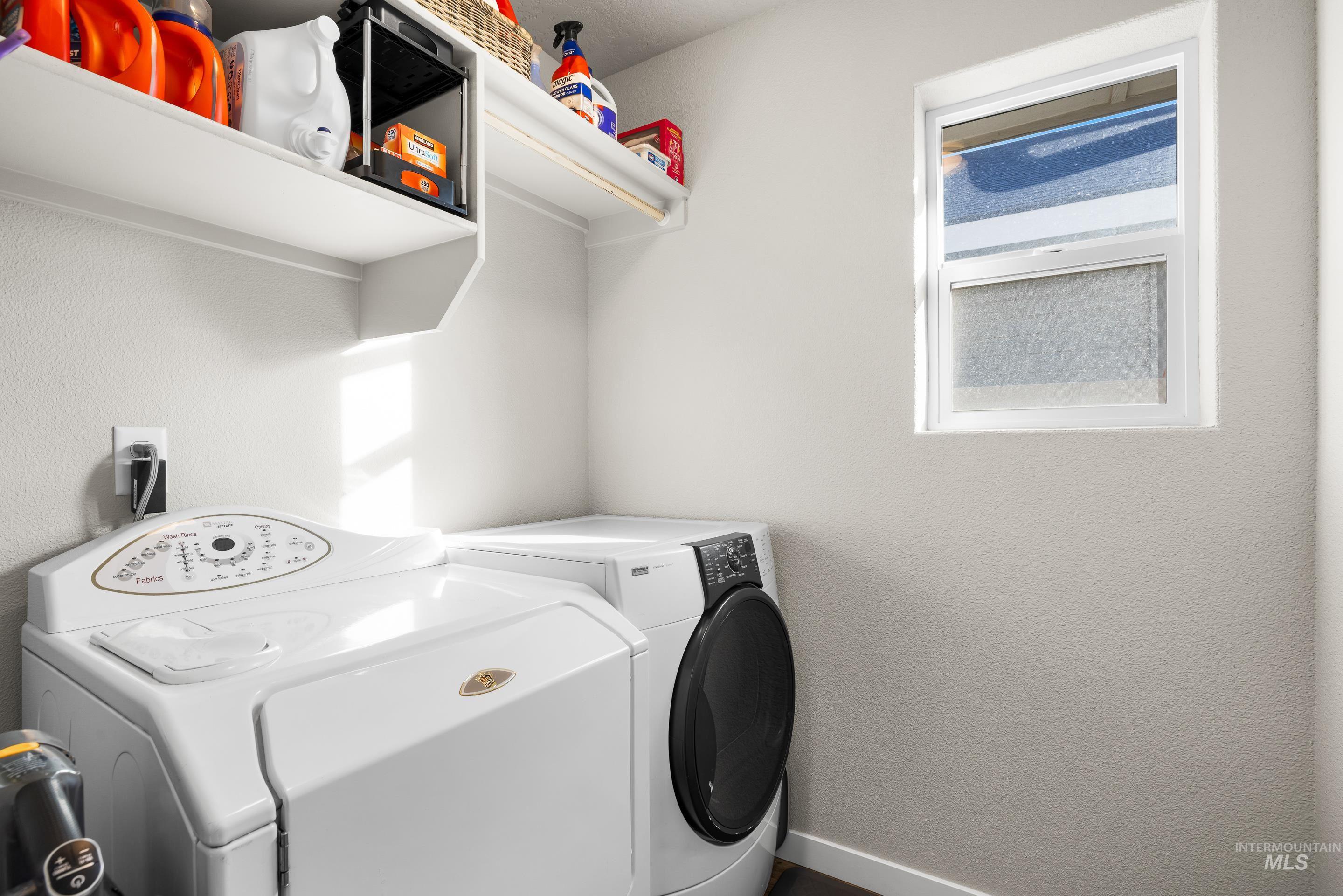 Laundry area with washing machine and clothes dryer and a textured wall