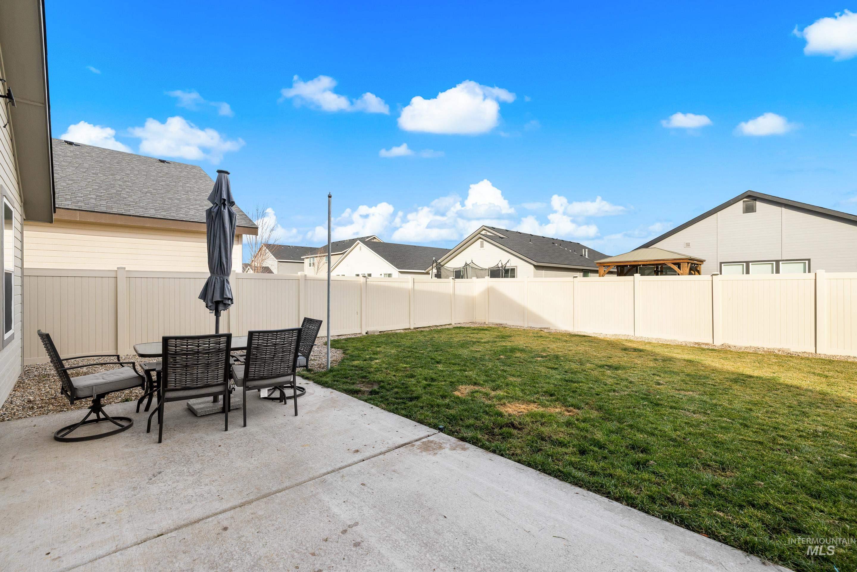 Fenced backyard featuring a patio, a residential view, and outdoor dining space