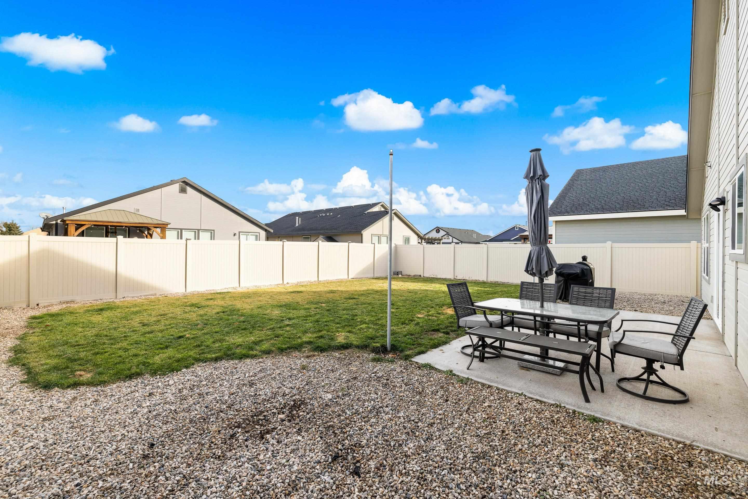 Fenced backyard featuring a patio area and a residential view