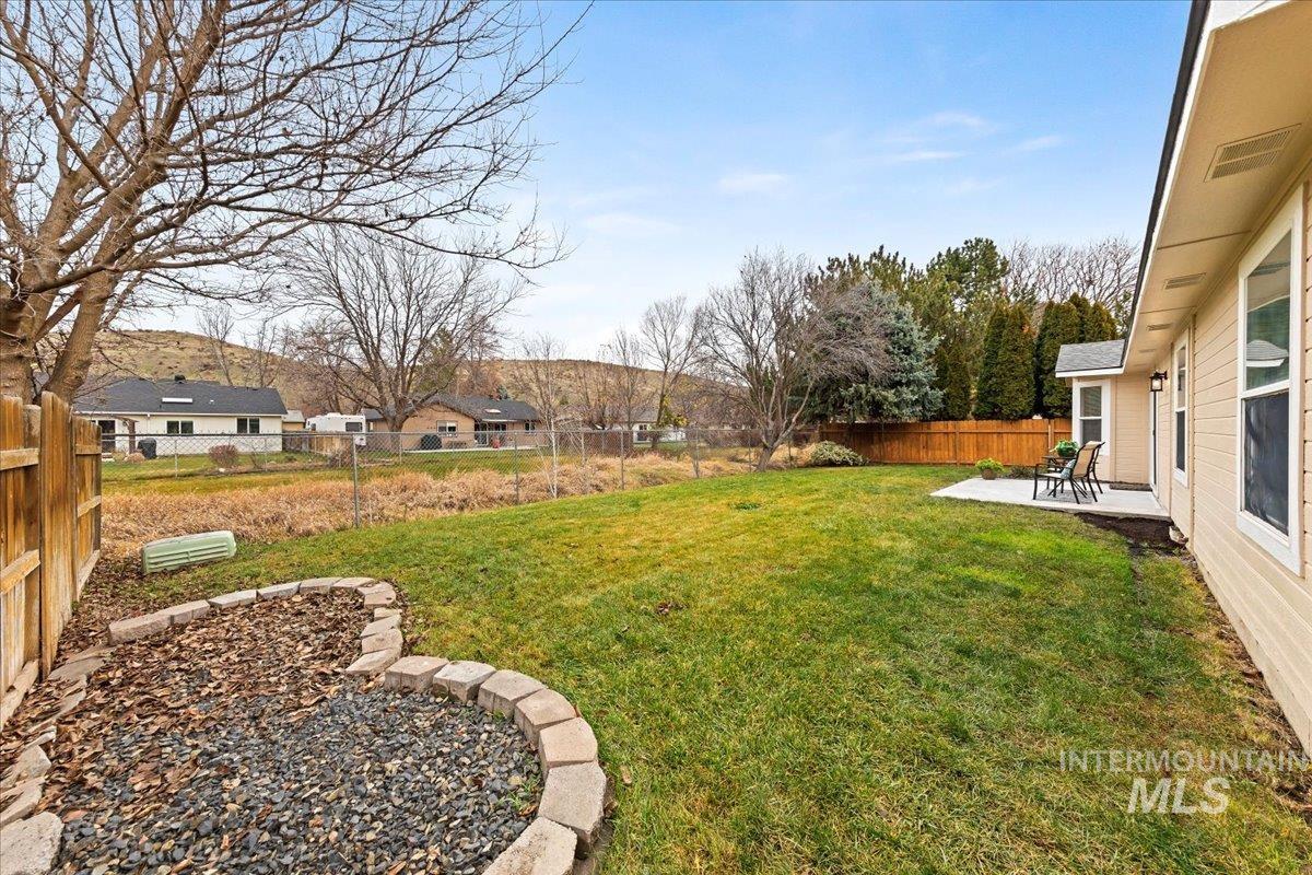 Fenced backyard featuring a patio area & Views of the Boise Foothills!