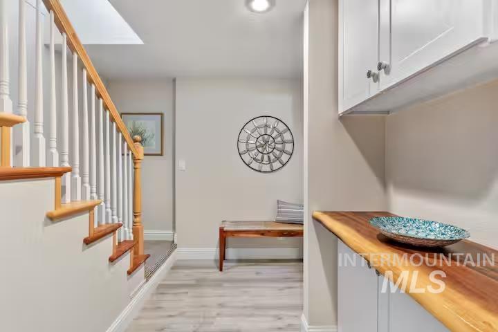 Entrance foyer featuring stairs and light wood-style flooring