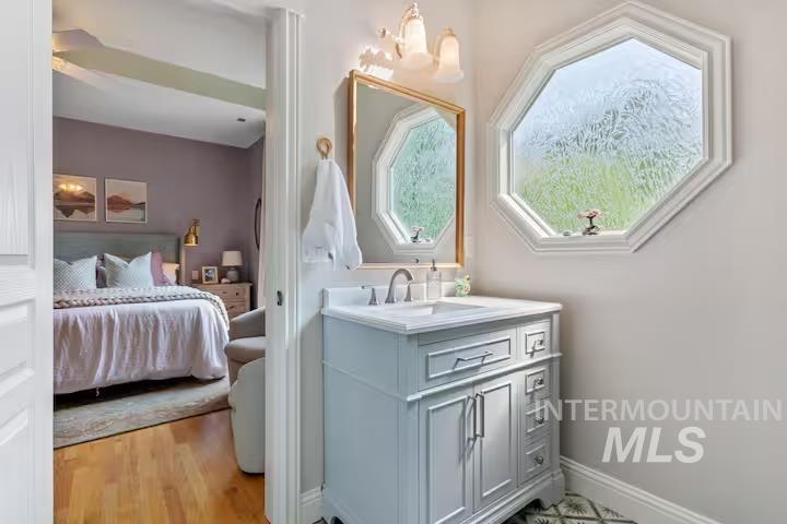 Bathroom featuring vanity, ensuite bath, and light wood finished floors