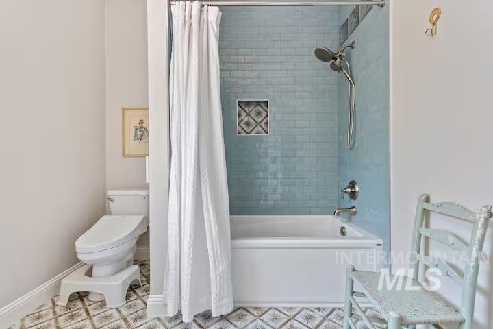 Bathroom featuring shower / tub combo and toilet