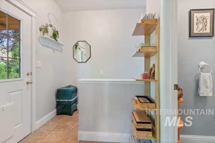 Foyer entrance featuring light tile patterned flooring and baseboards