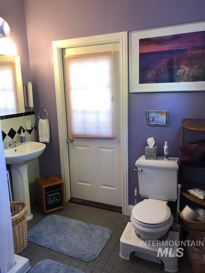 Bathroom featuring tasteful backsplash and toilet
