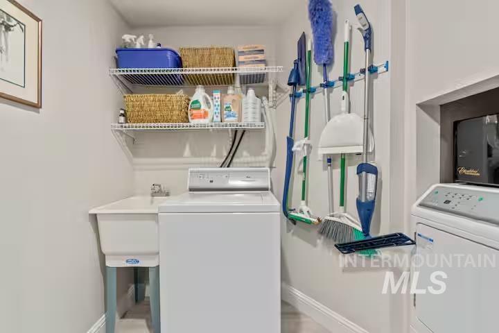 Washroom featuring baseboards and independent washer and dryer
