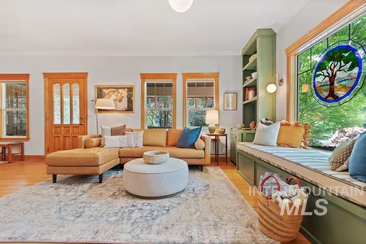 Living area featuring light wood-type flooring and crown molding