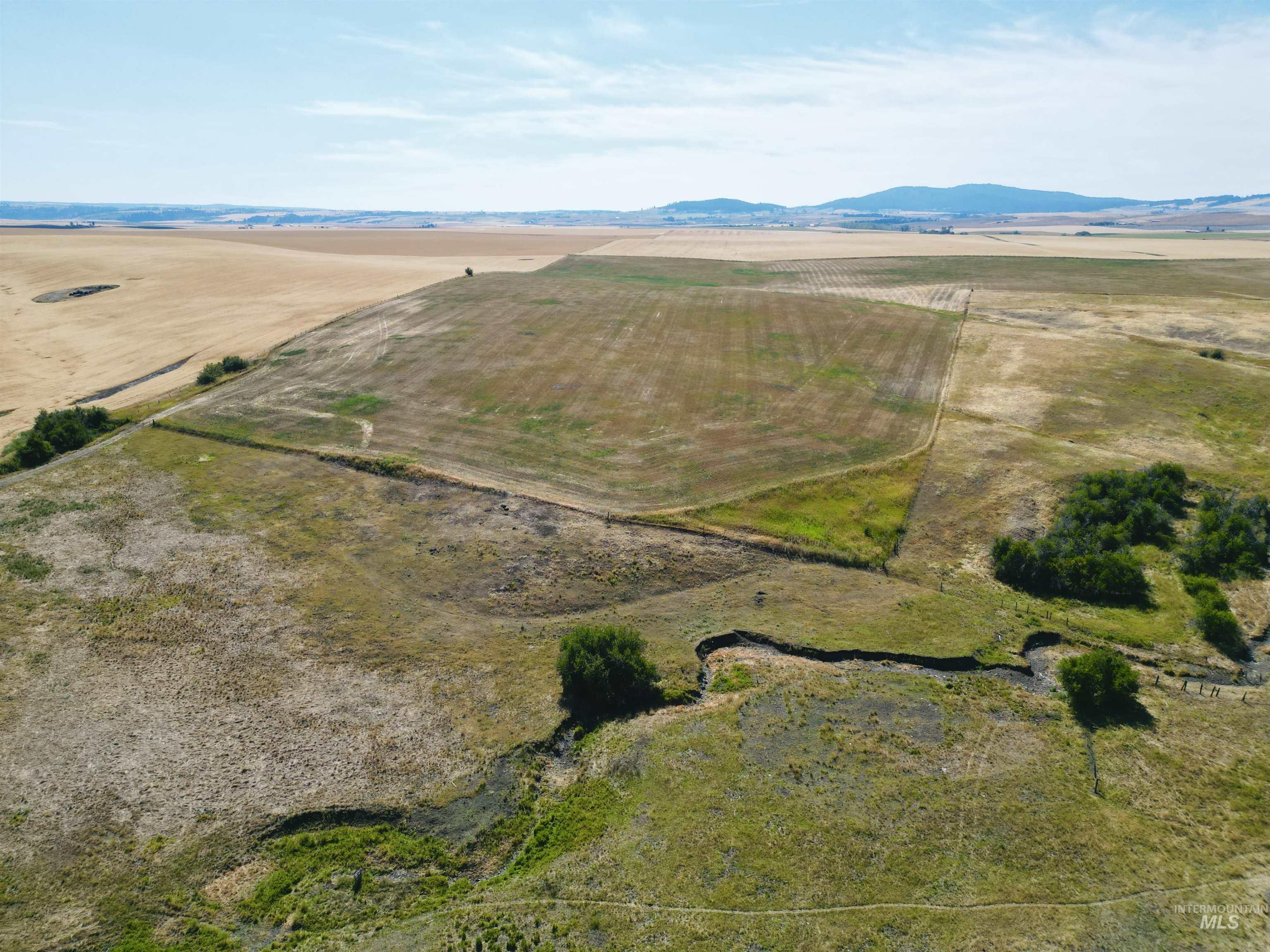 Aerial overview of property's location with rural landscape and mountains