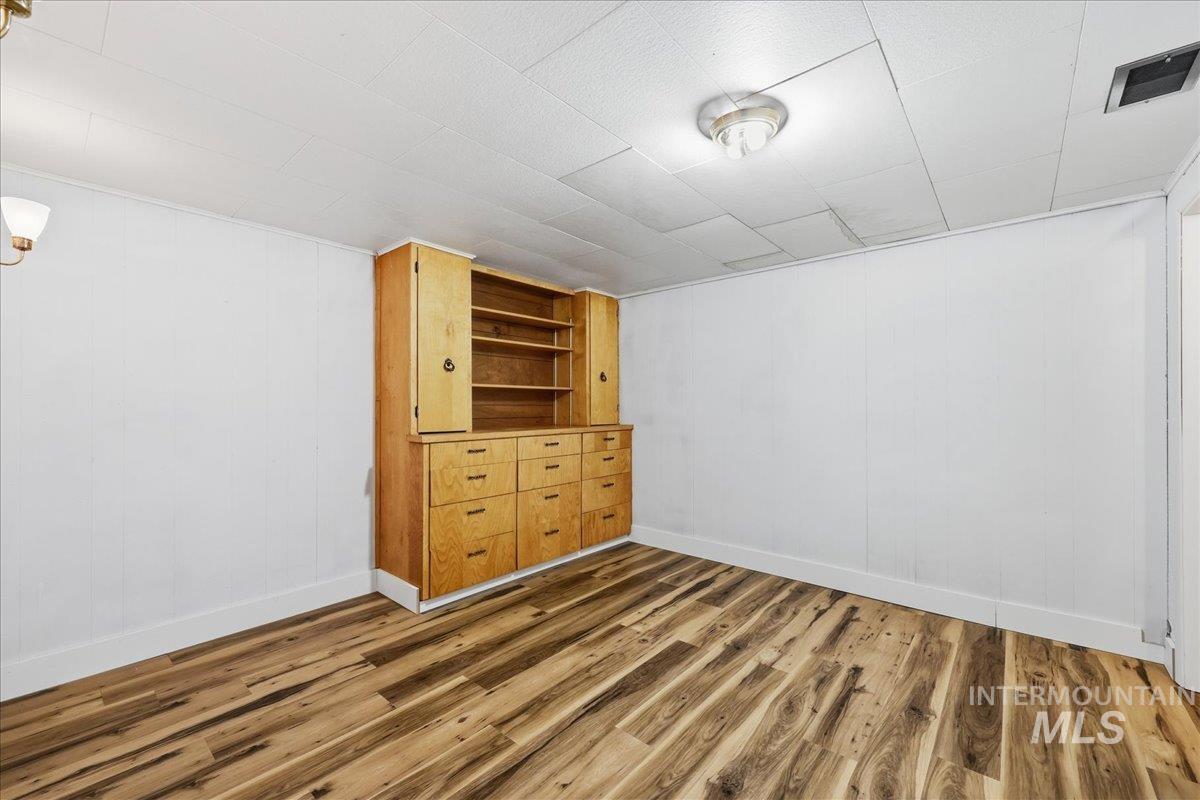 Basement featuring wood walls and wood finished floors