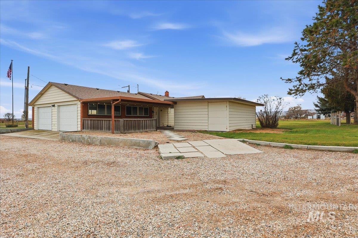 View of front of house with a front yard, an attached garage, and driveway
