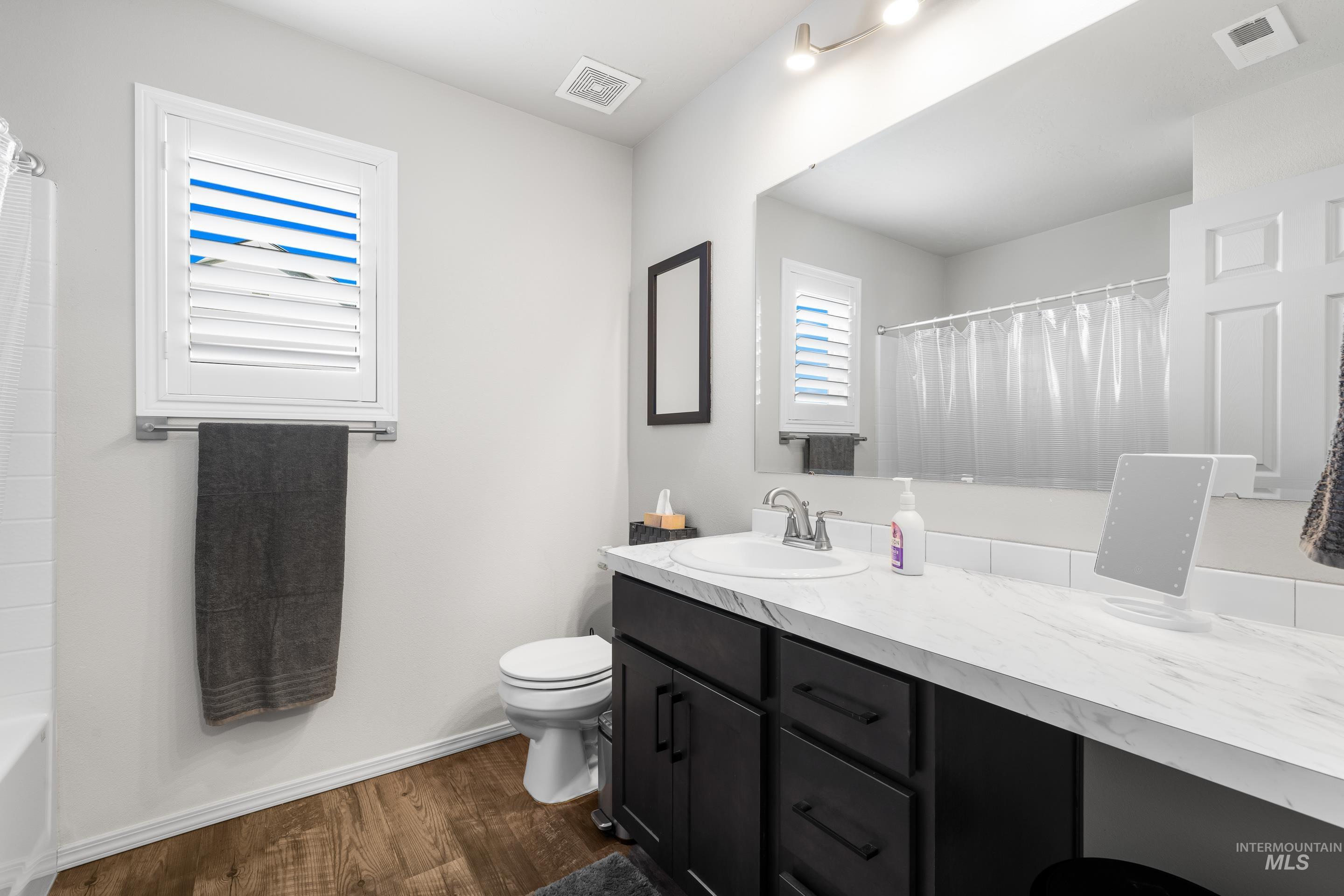 Bathroom with vanity and dark wood-style floors