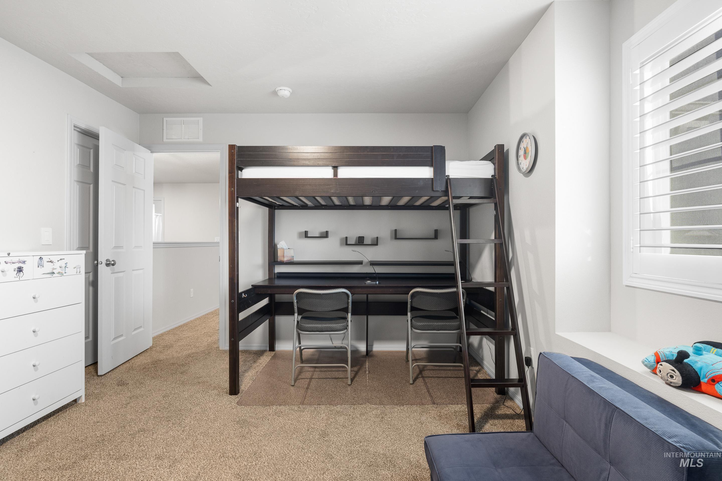 Bedroom with light carpet and attic access