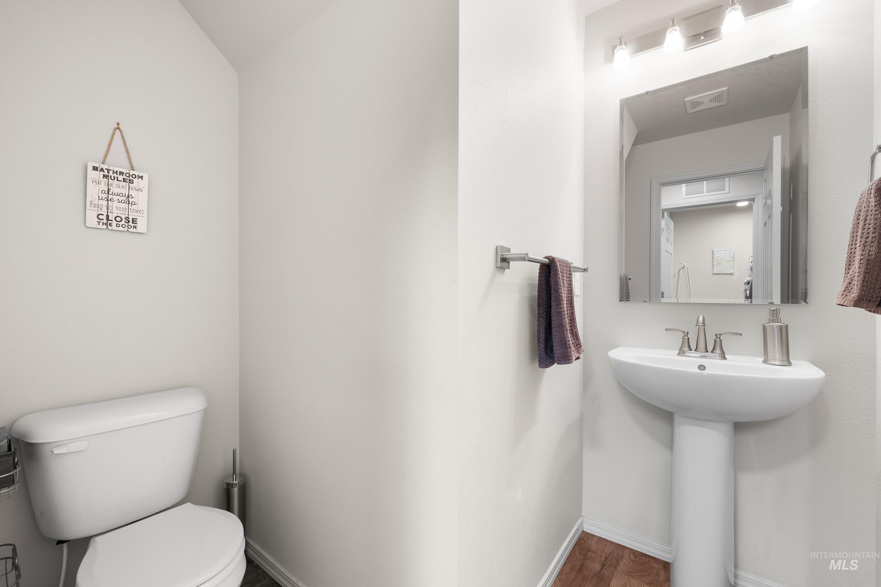 Half bathroom with toilet and baseboards