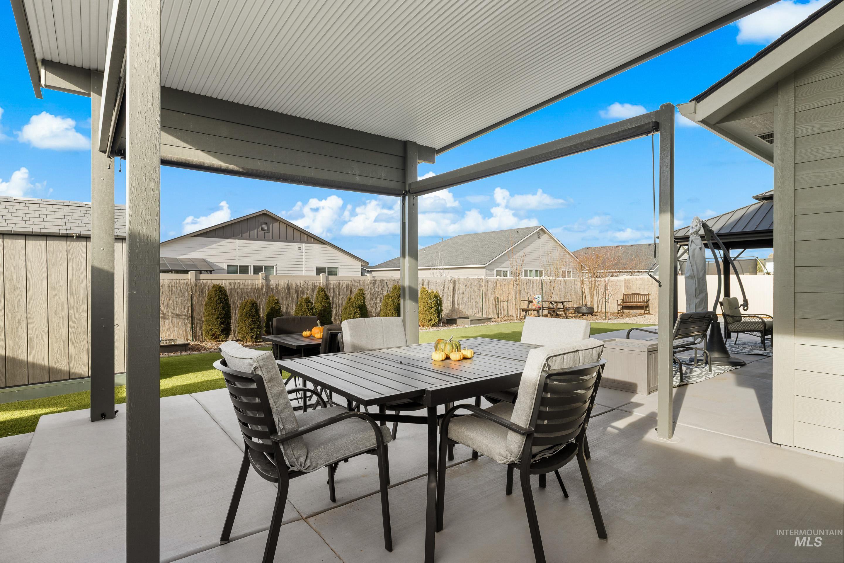 Fenced backyard featuring outdoor dining area and a patio