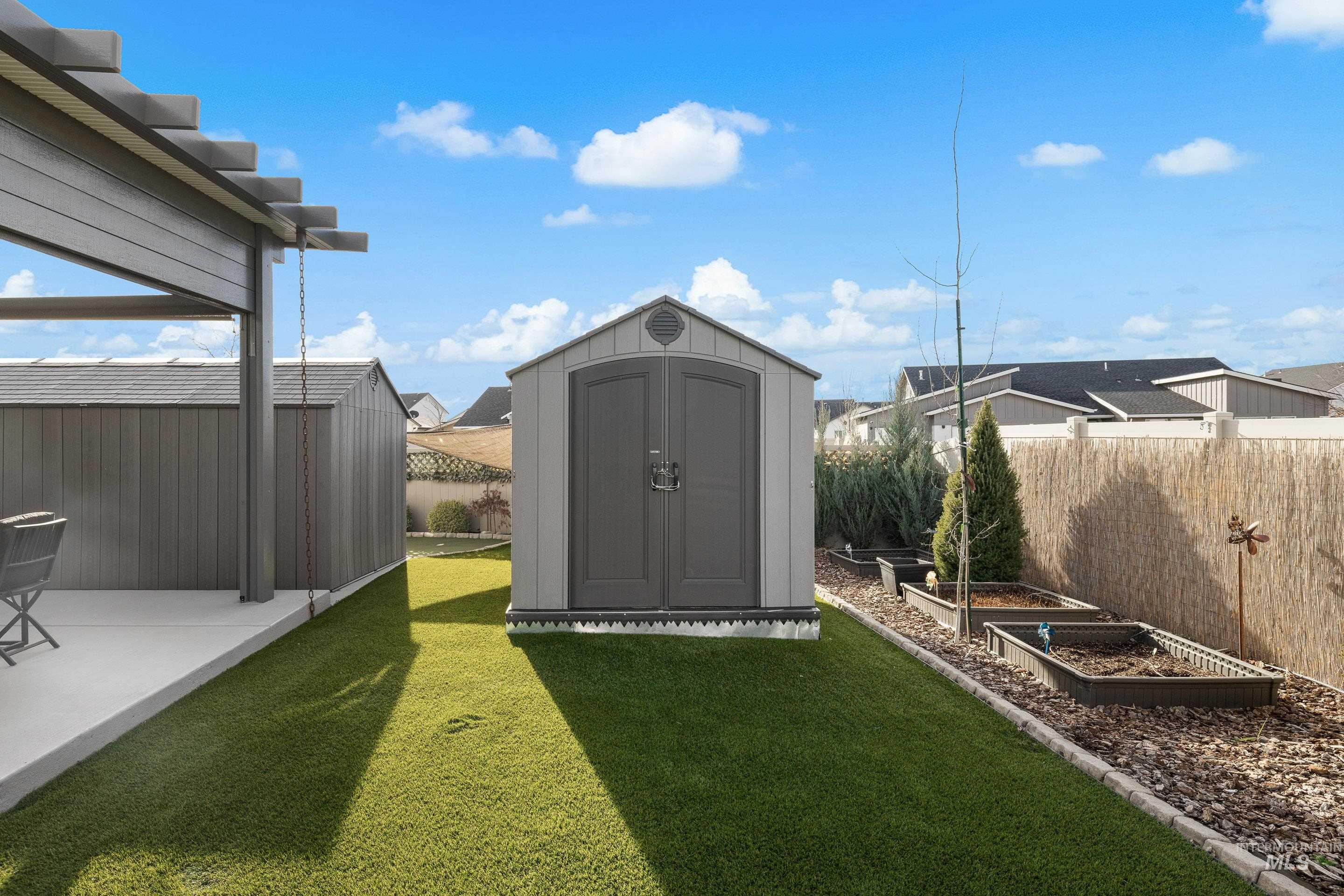 View of yard featuring a storage shed, a vegetable garden, and a patio area