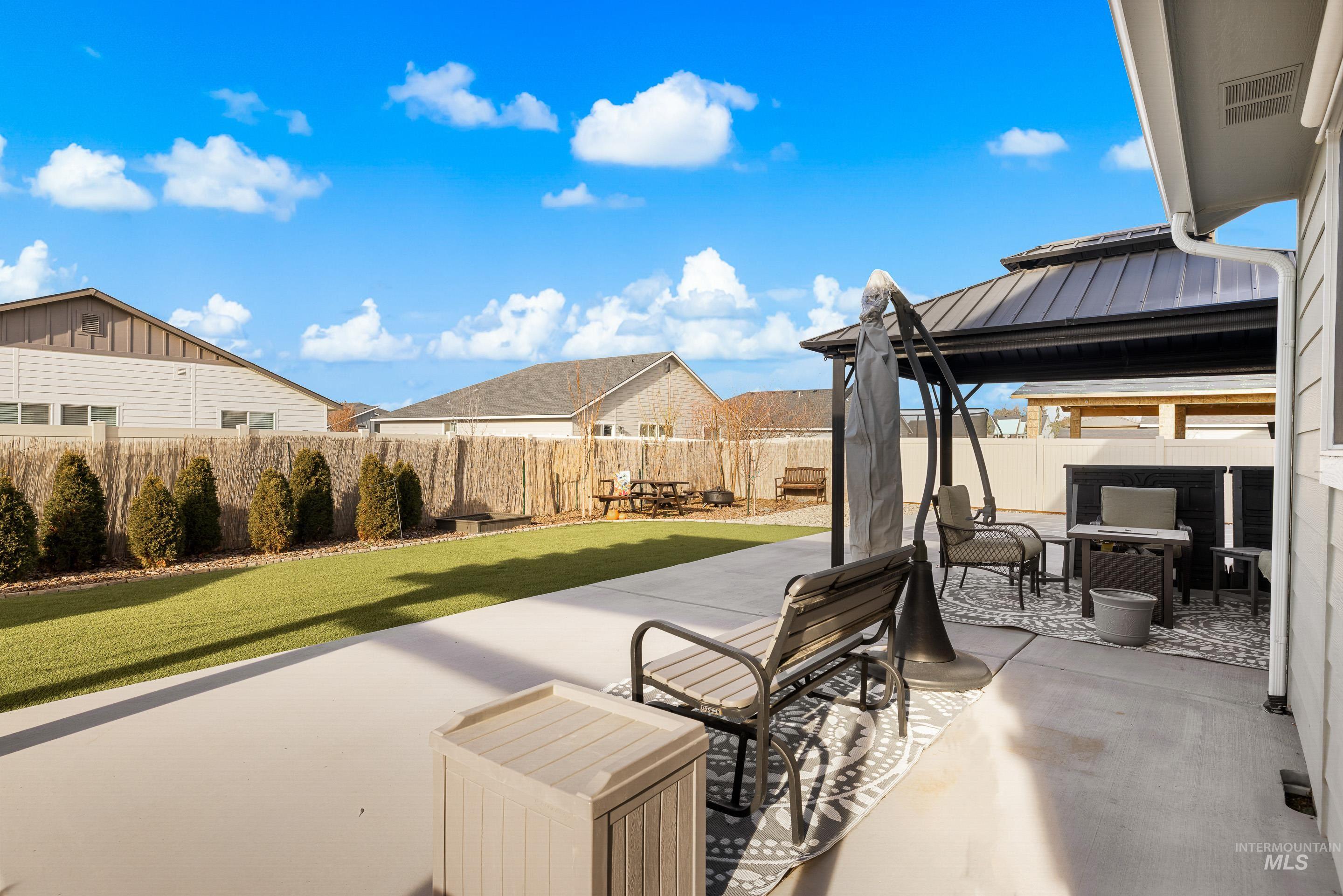 Fenced backyard with a patio area, a gazebo, and outdoor dining space