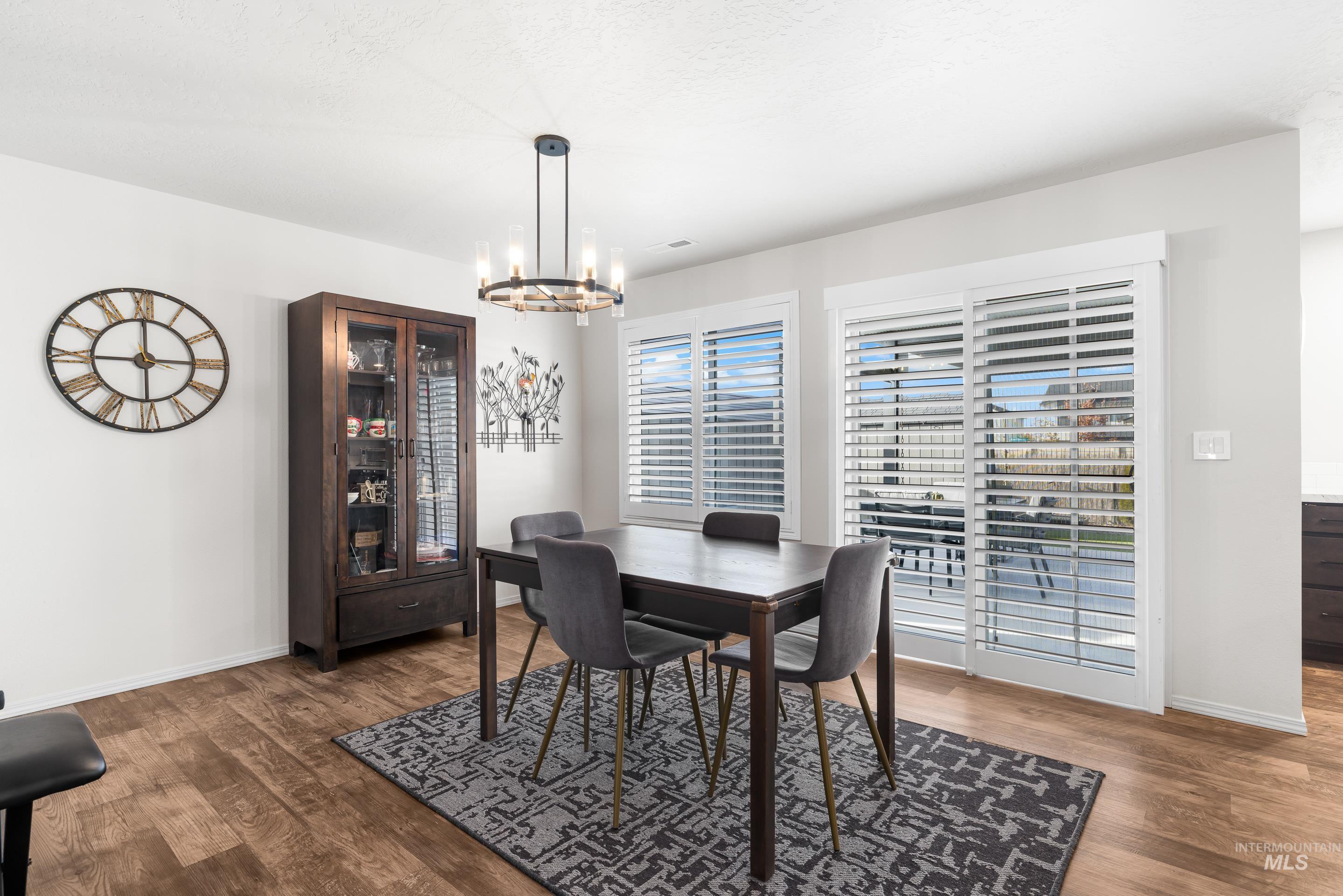 Dining space featuring dark wood finished floors and a chandelier