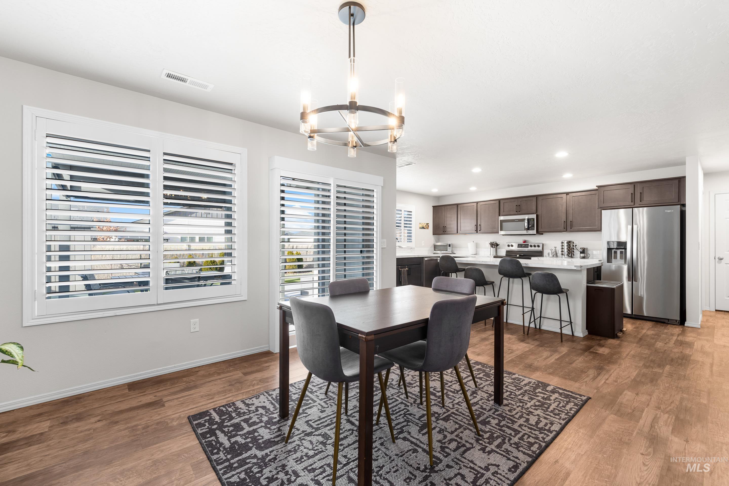 Dining space featuring a chandelier, dark wood-style flooring, and recessed lighting