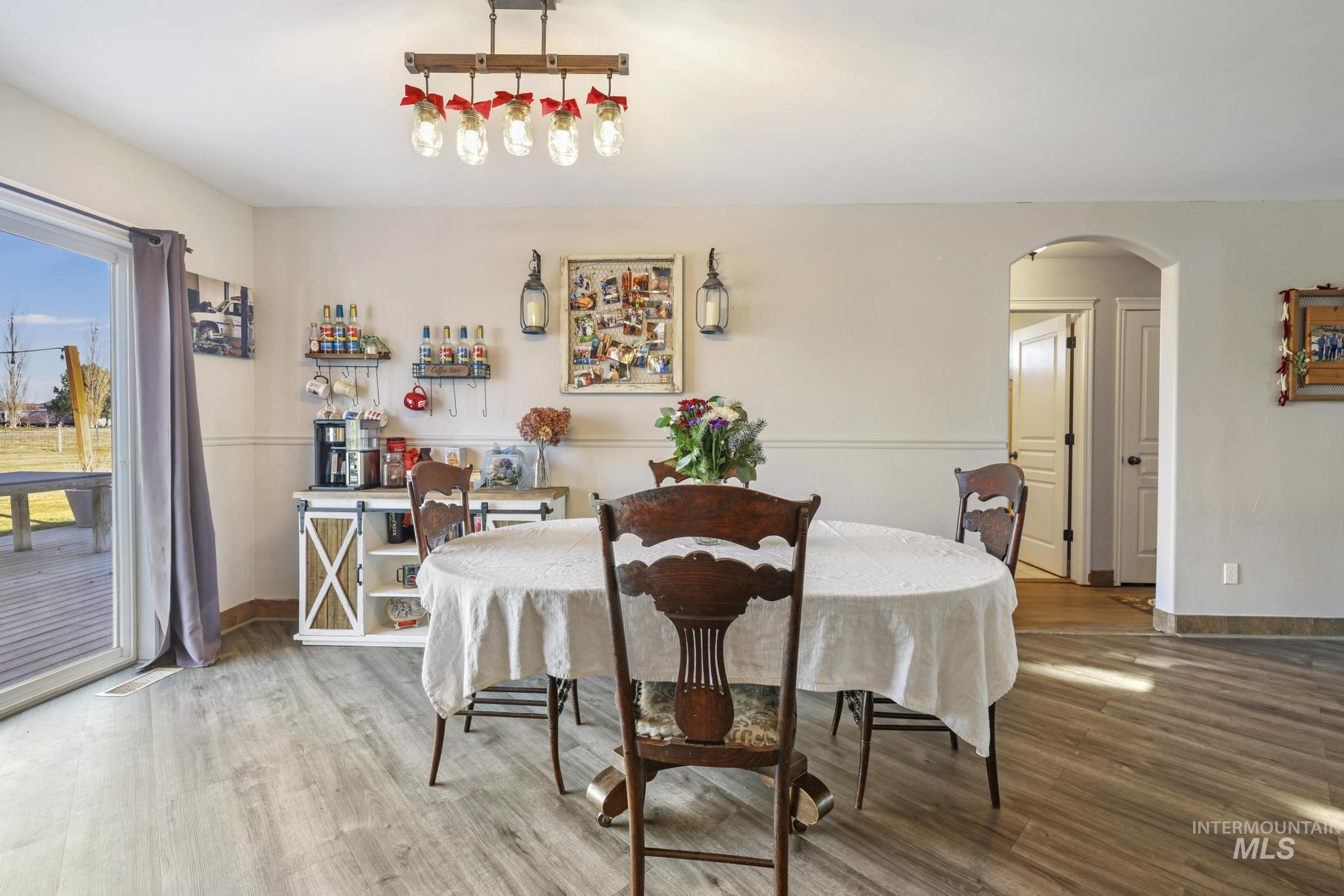 Dining space with arched walkways and wood finished floors