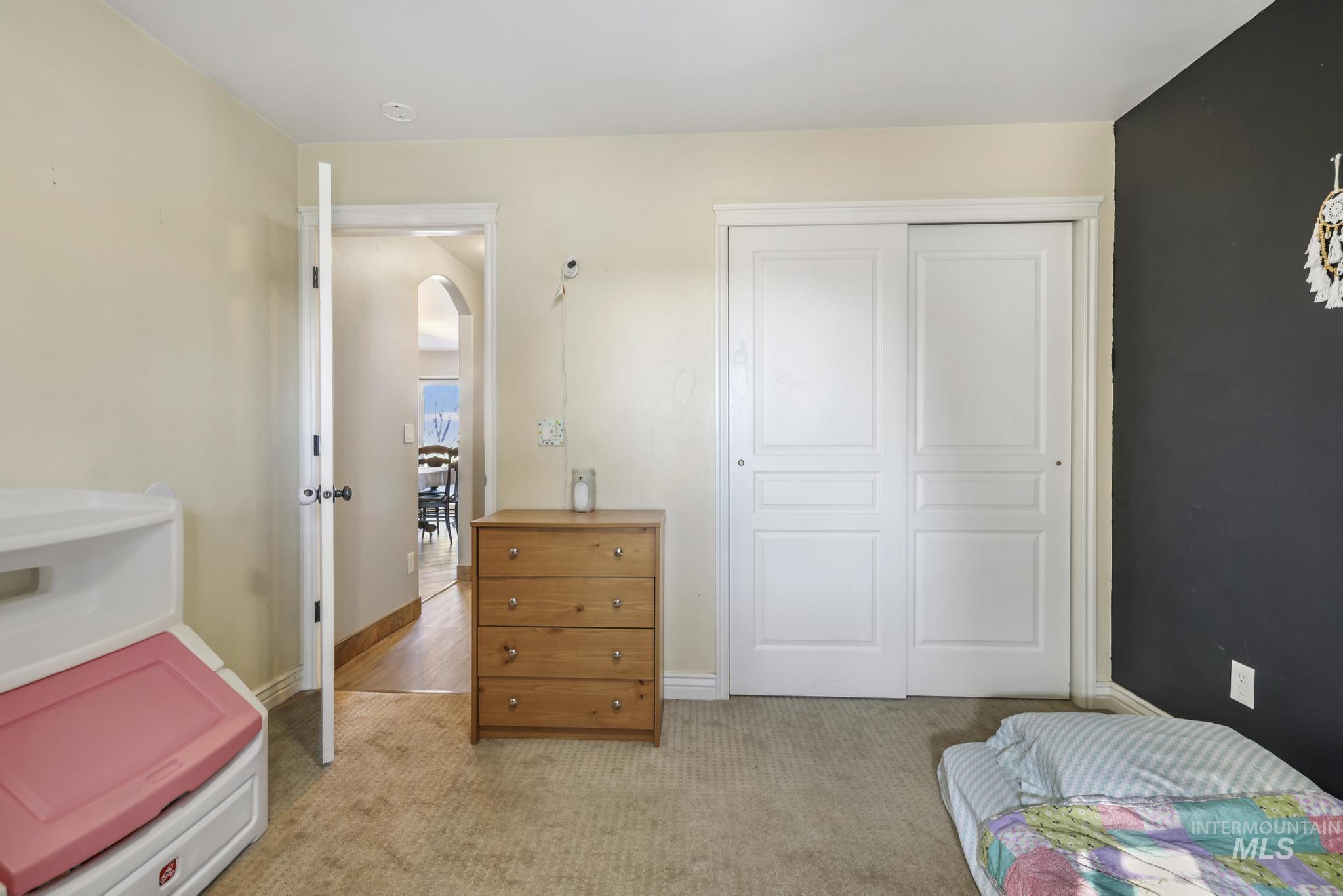 Bedroom with light colored carpet and a closet