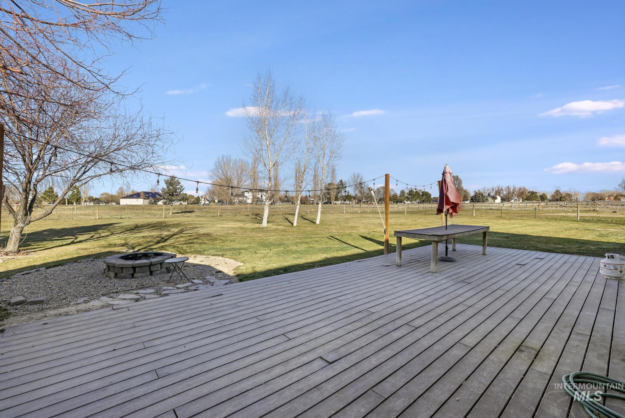 Wooden terrace with a fire pit and a rural view