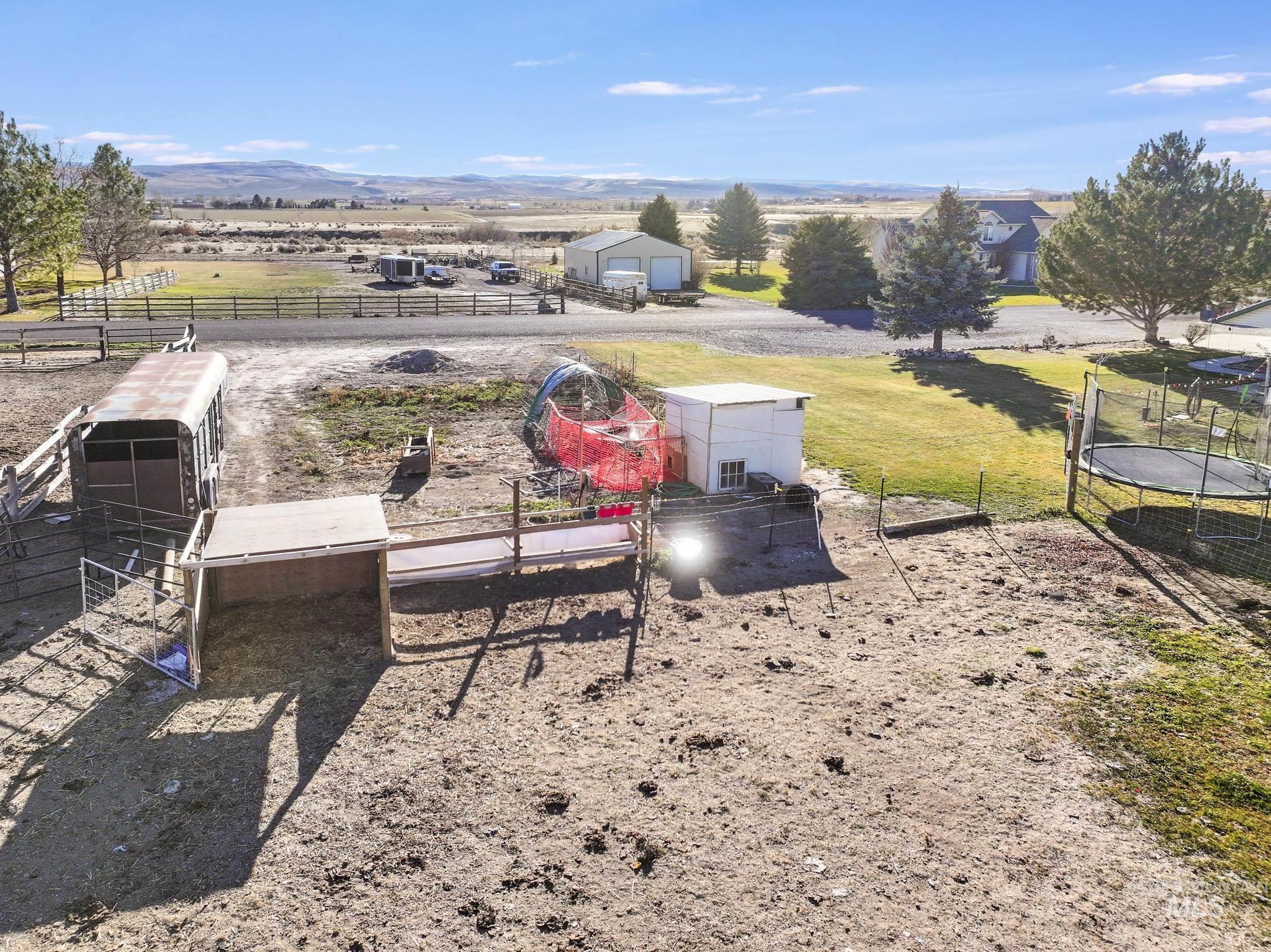 View of yard featuring an outbuilding, a trampoline, and a rural view