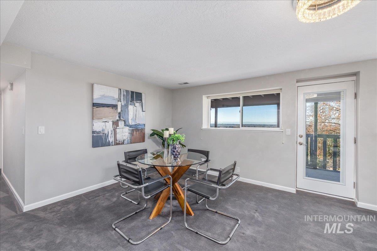 Dining space with dark carpet and a textured ceiling