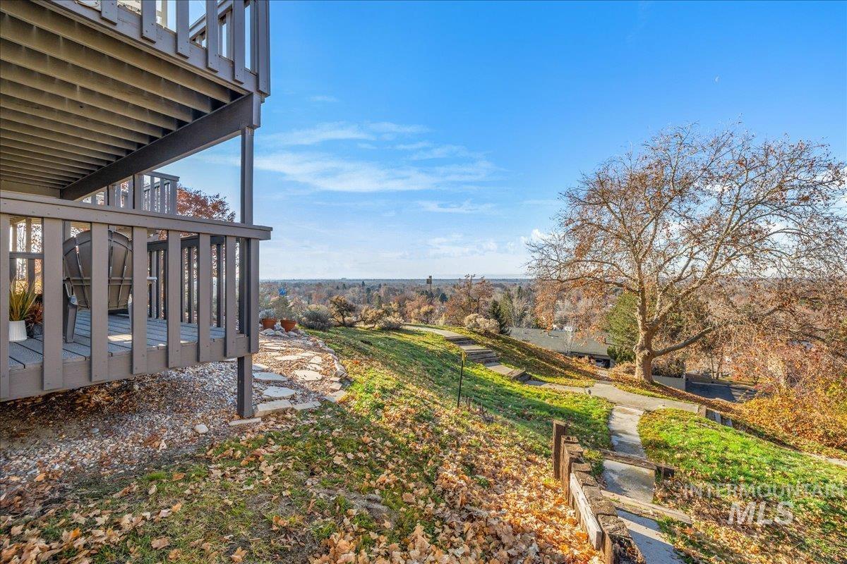 View of yard with a deck, a balcony, and stairway