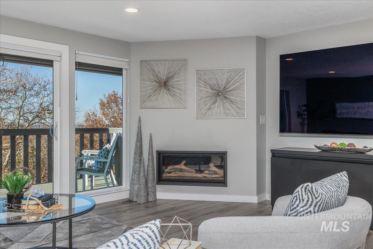 Living area with wood finished floors and a glass covered fireplace