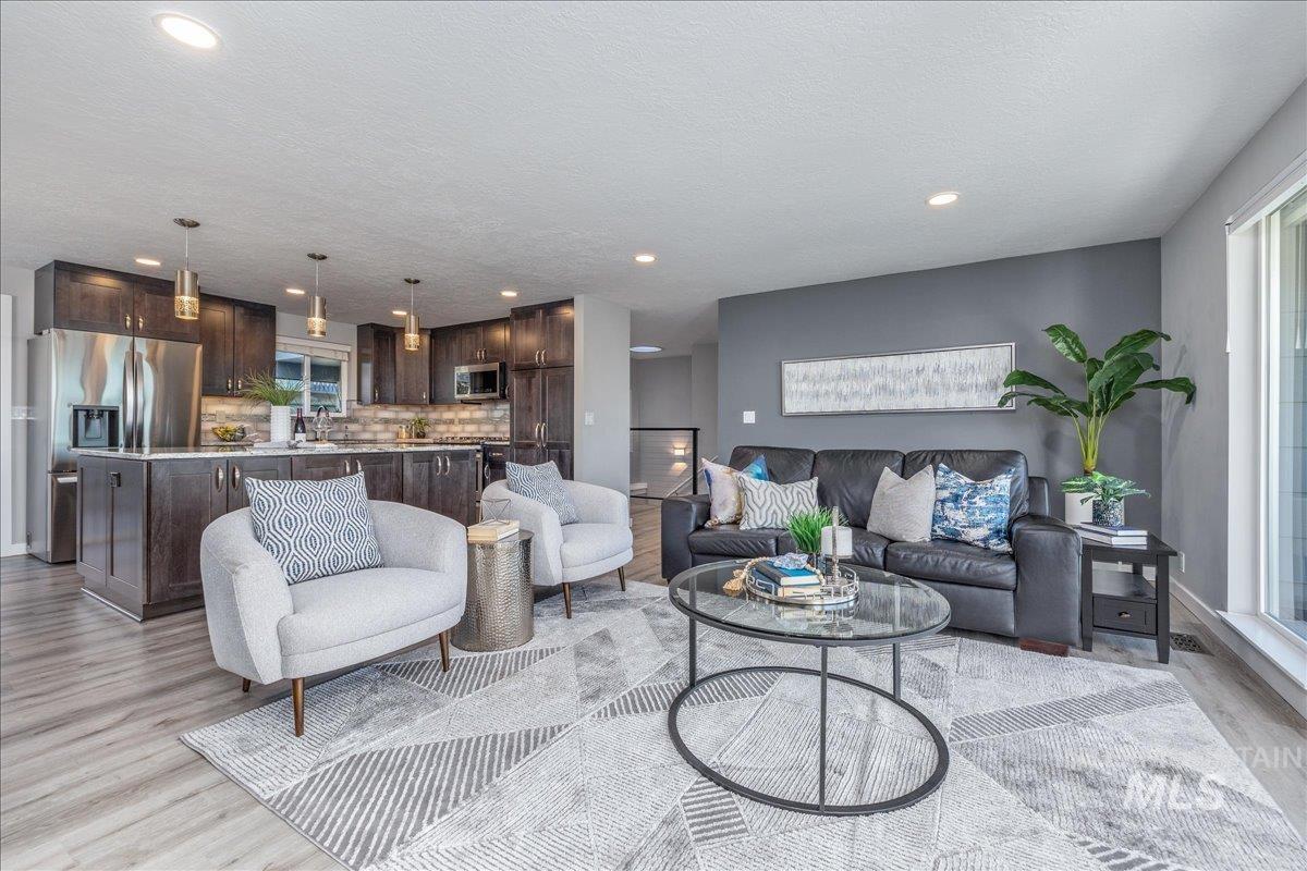 Living room with light wood-type flooring, recessed lighting, and a textured ceiling