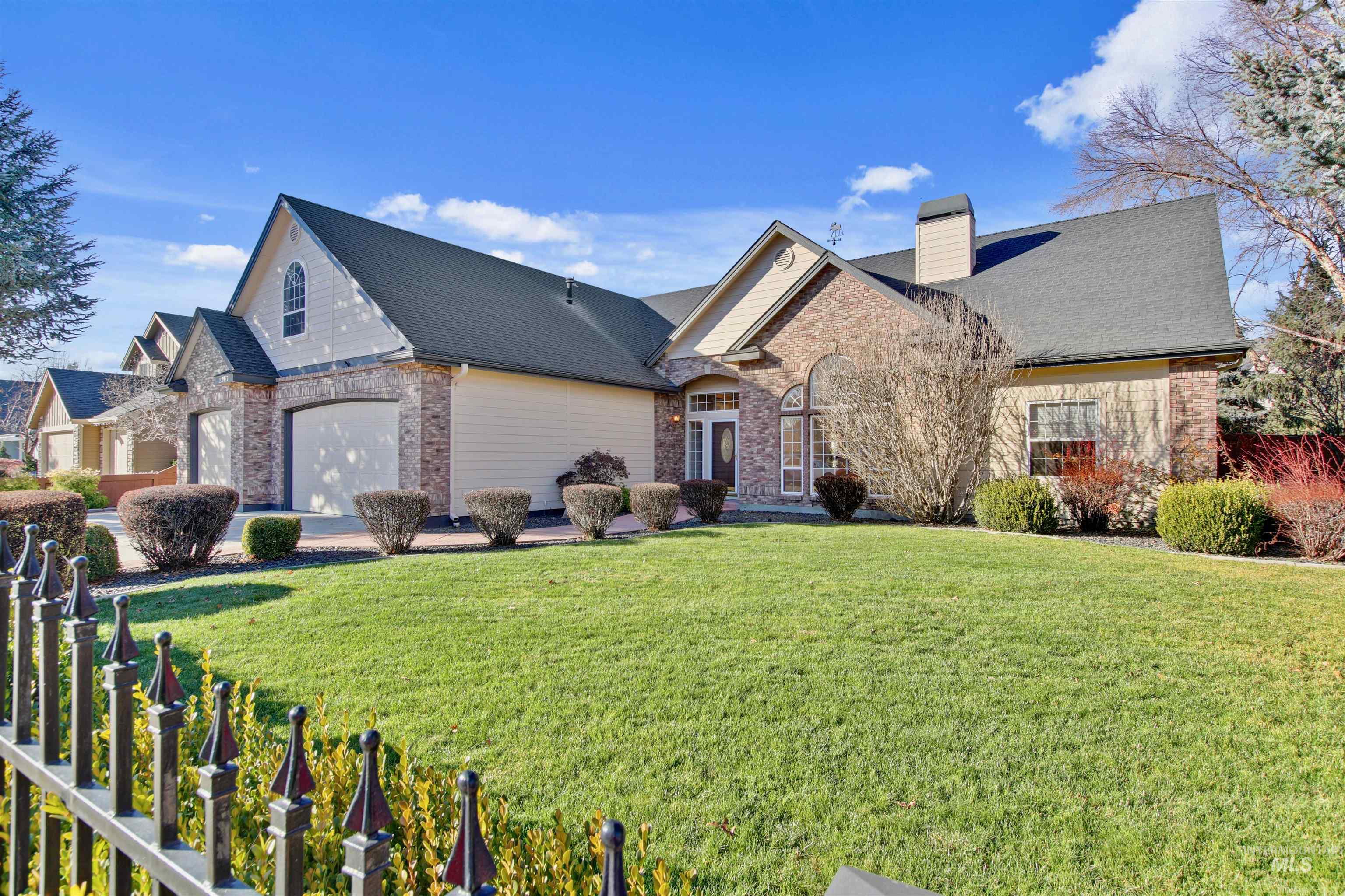 View of front of property featuring brick siding, a front yard, and a chimney