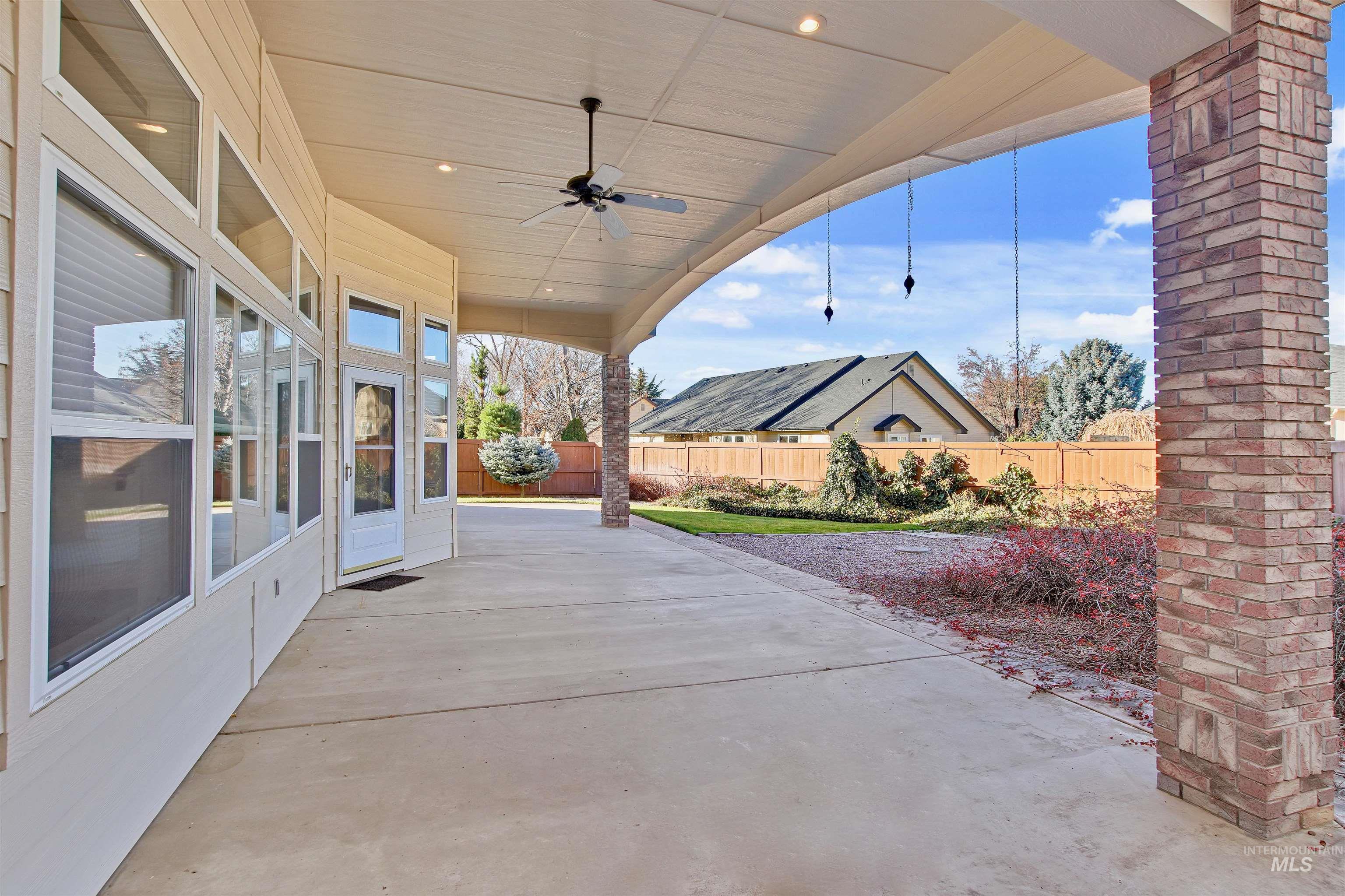 Fenced backyard with a ceiling fan and a patio