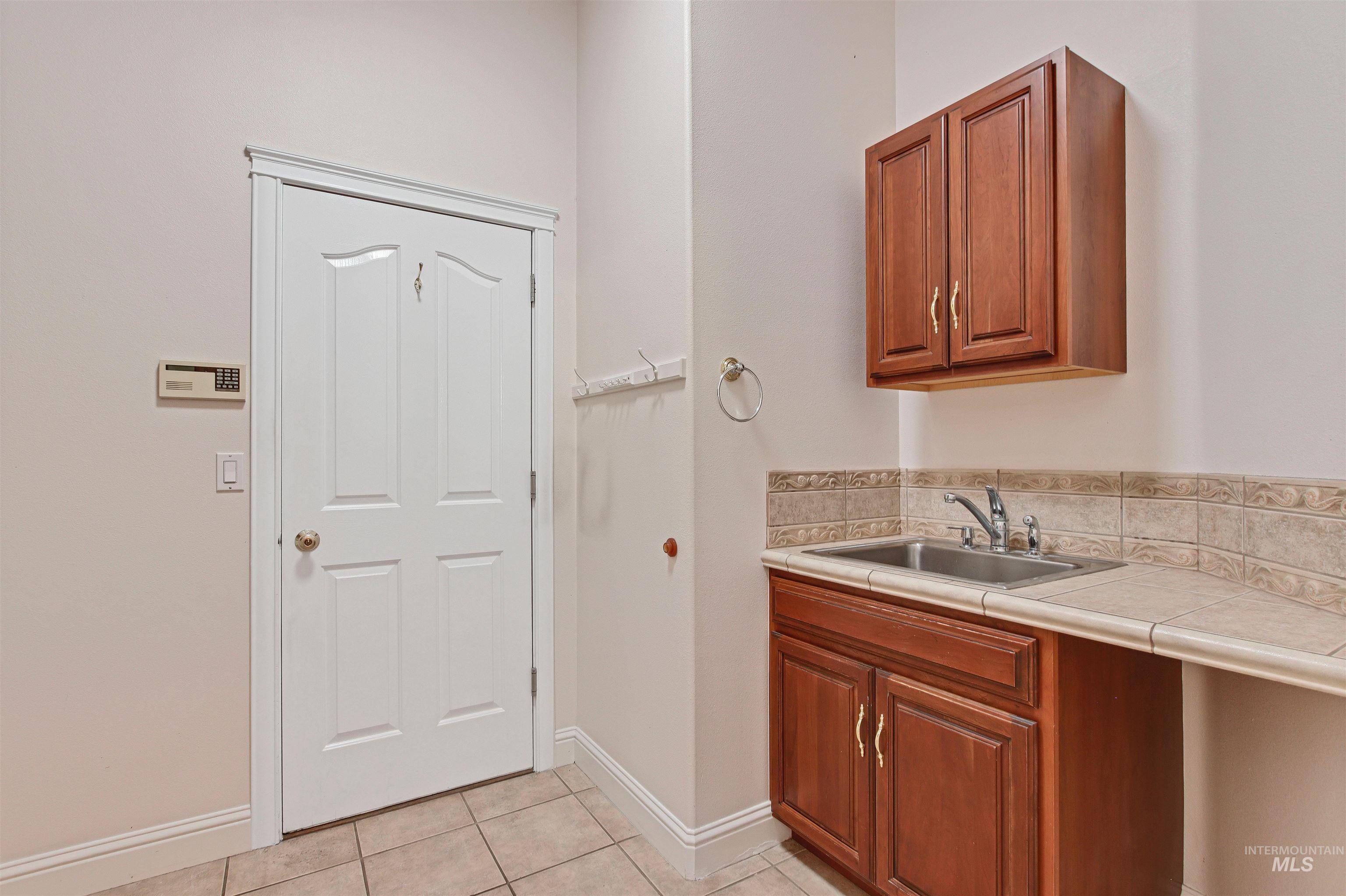 Kitchen featuring brown cabinetry, light tile patterned flooring, and tile counters