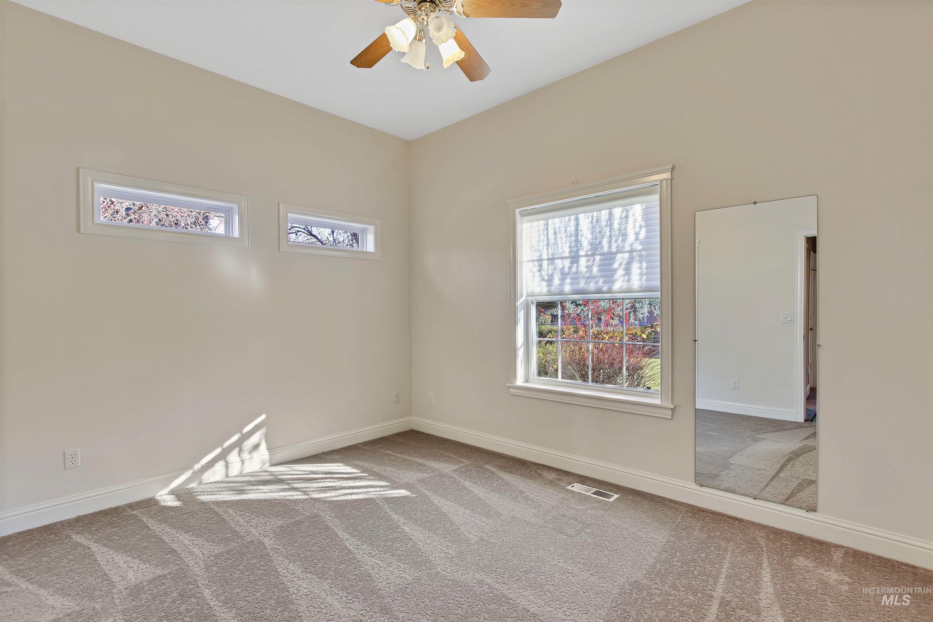 Spare room featuring light carpet and ceiling fan