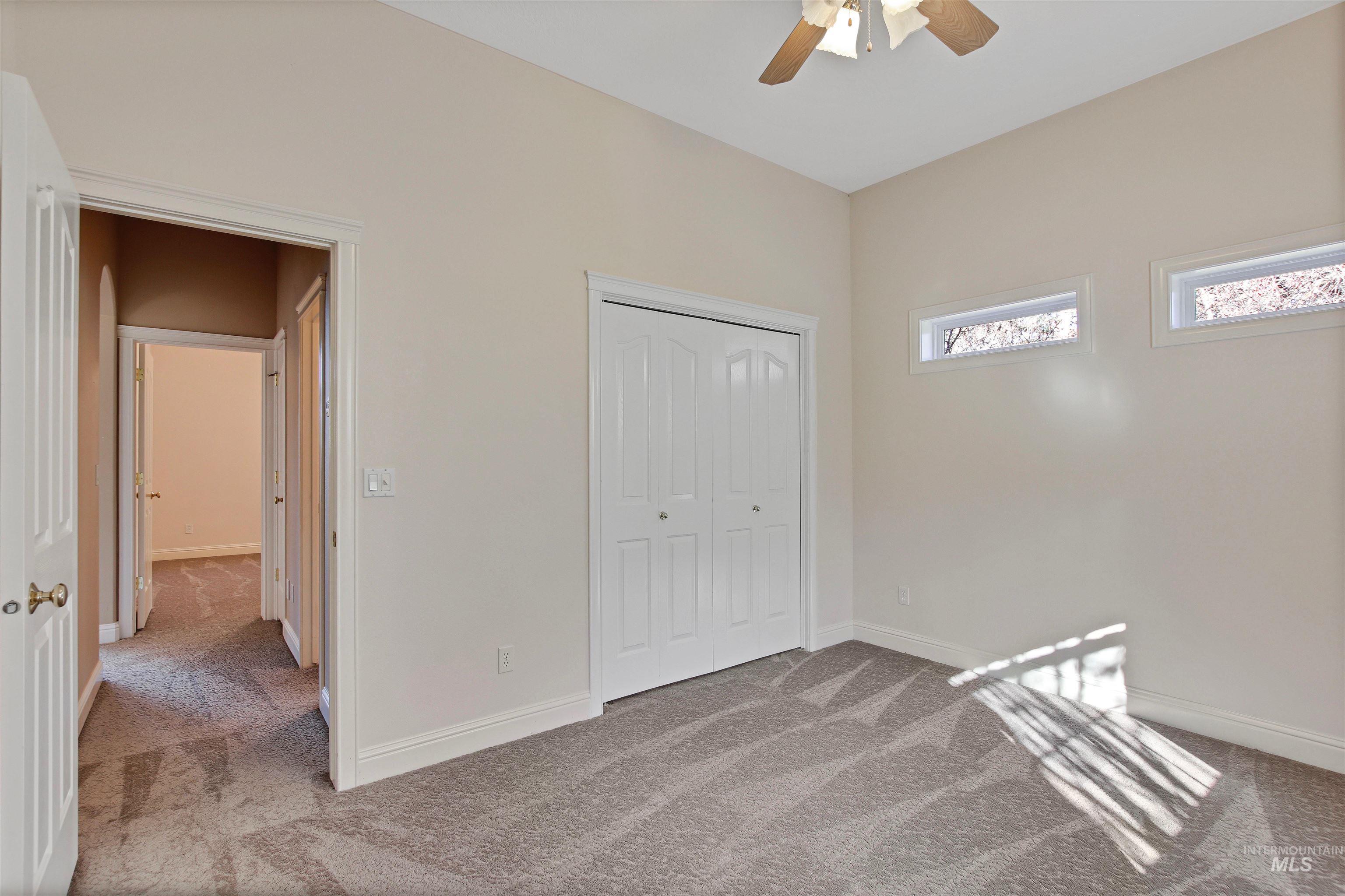 Unfurnished bedroom featuring carpet, a closet, and a ceiling fan