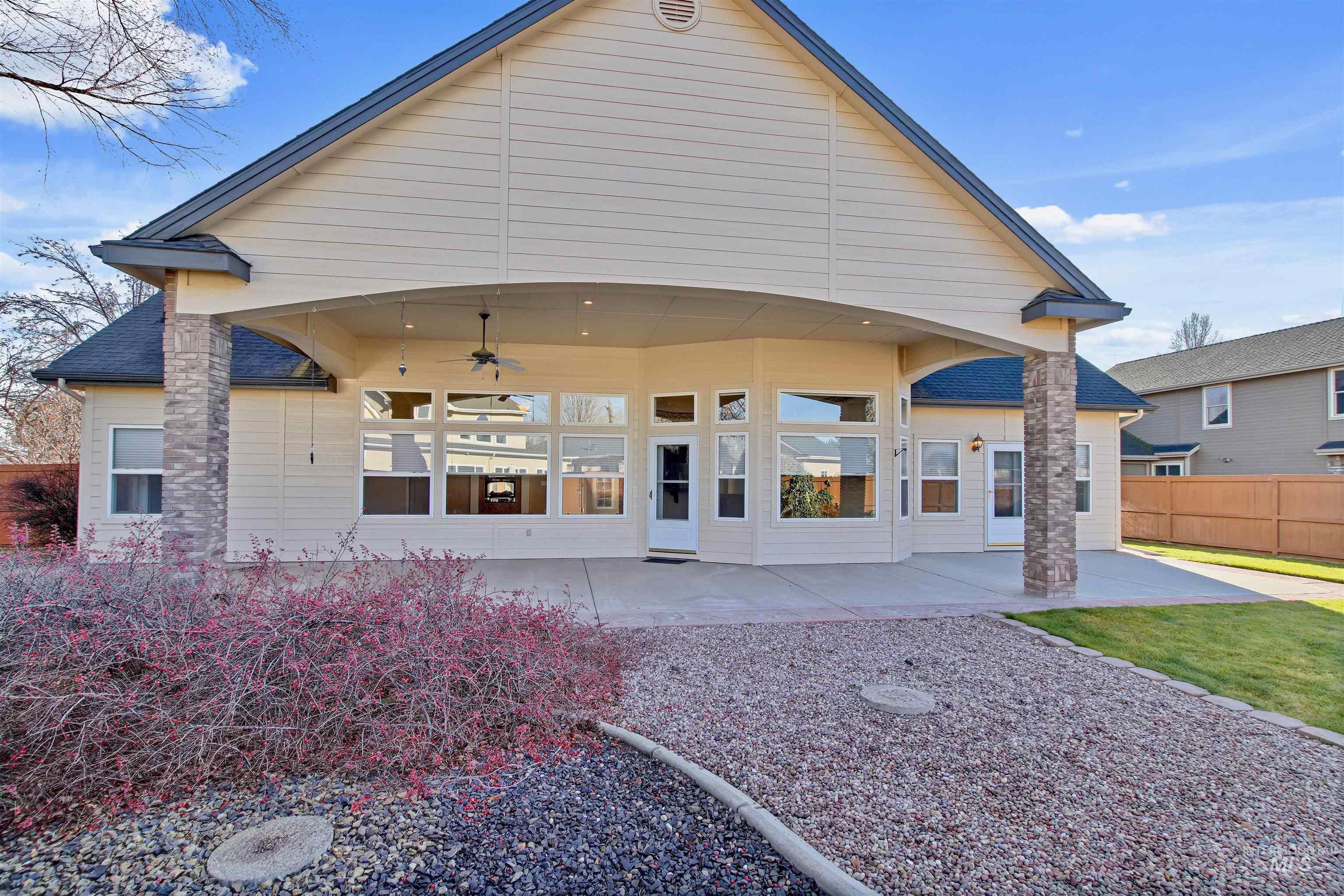 Back of property featuring ceiling fan and a patio