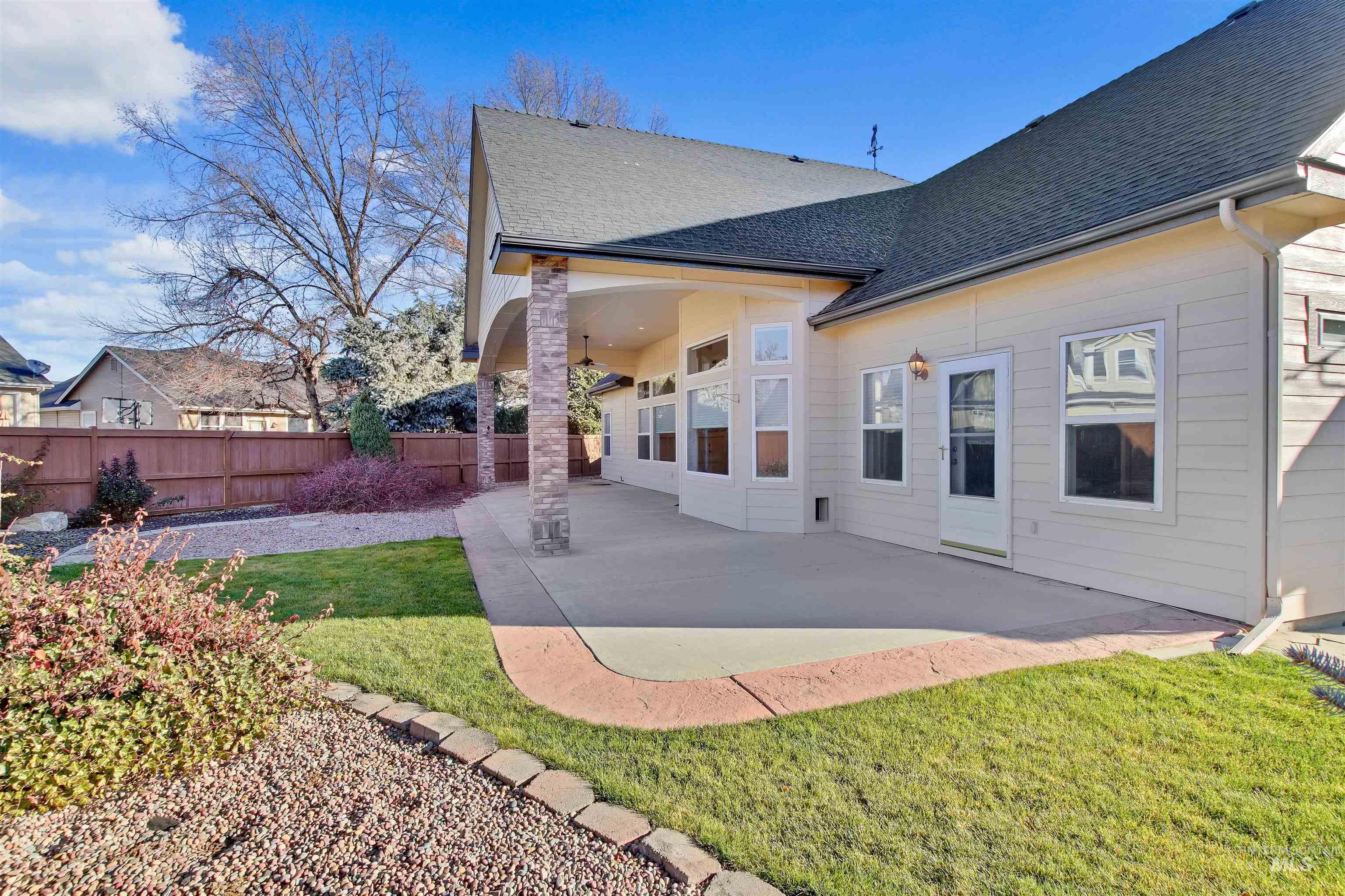 Rear view of house featuring a patio area and a shingled roof