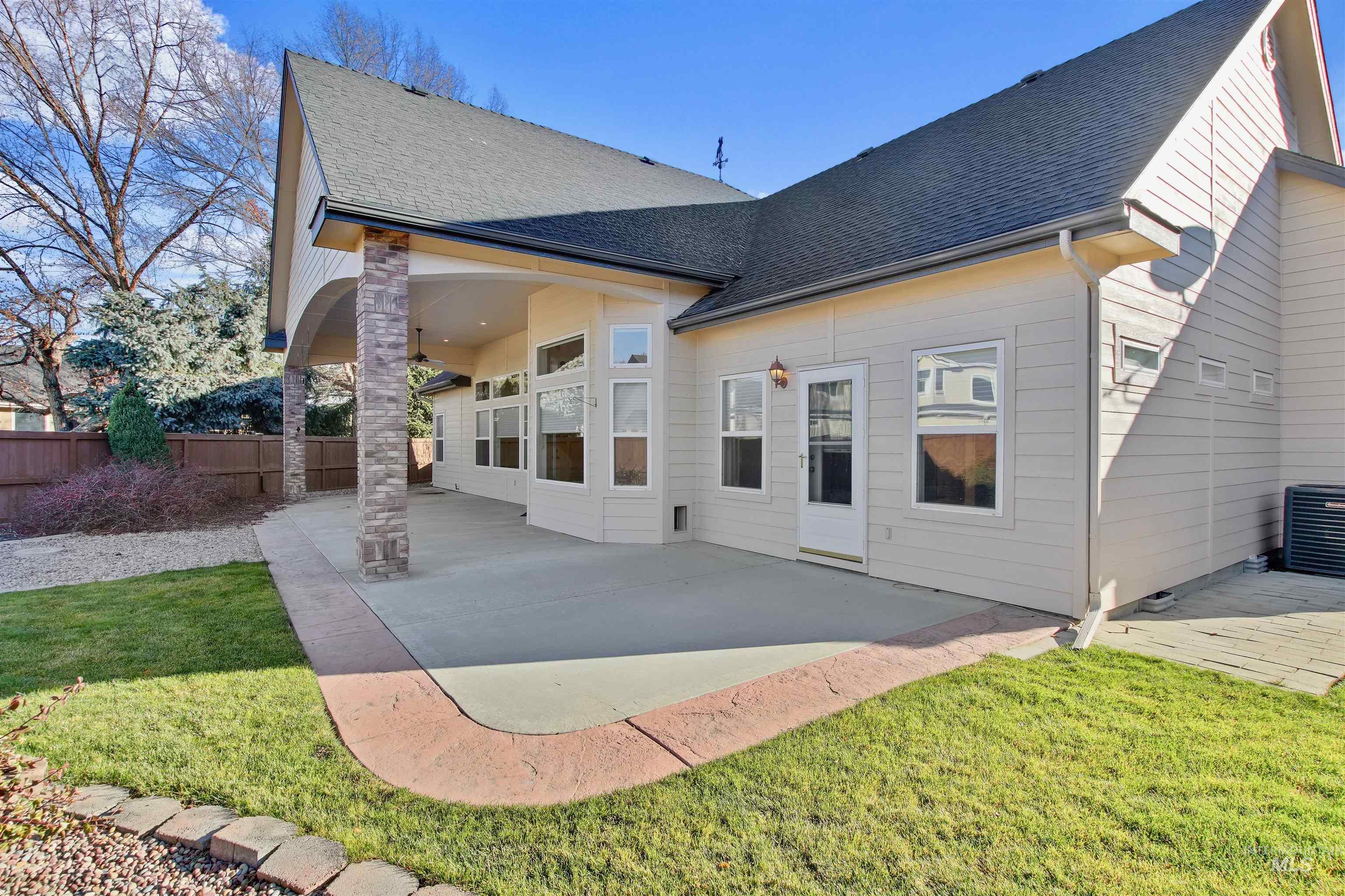 Rear view of house featuring a patio and roof with shingles