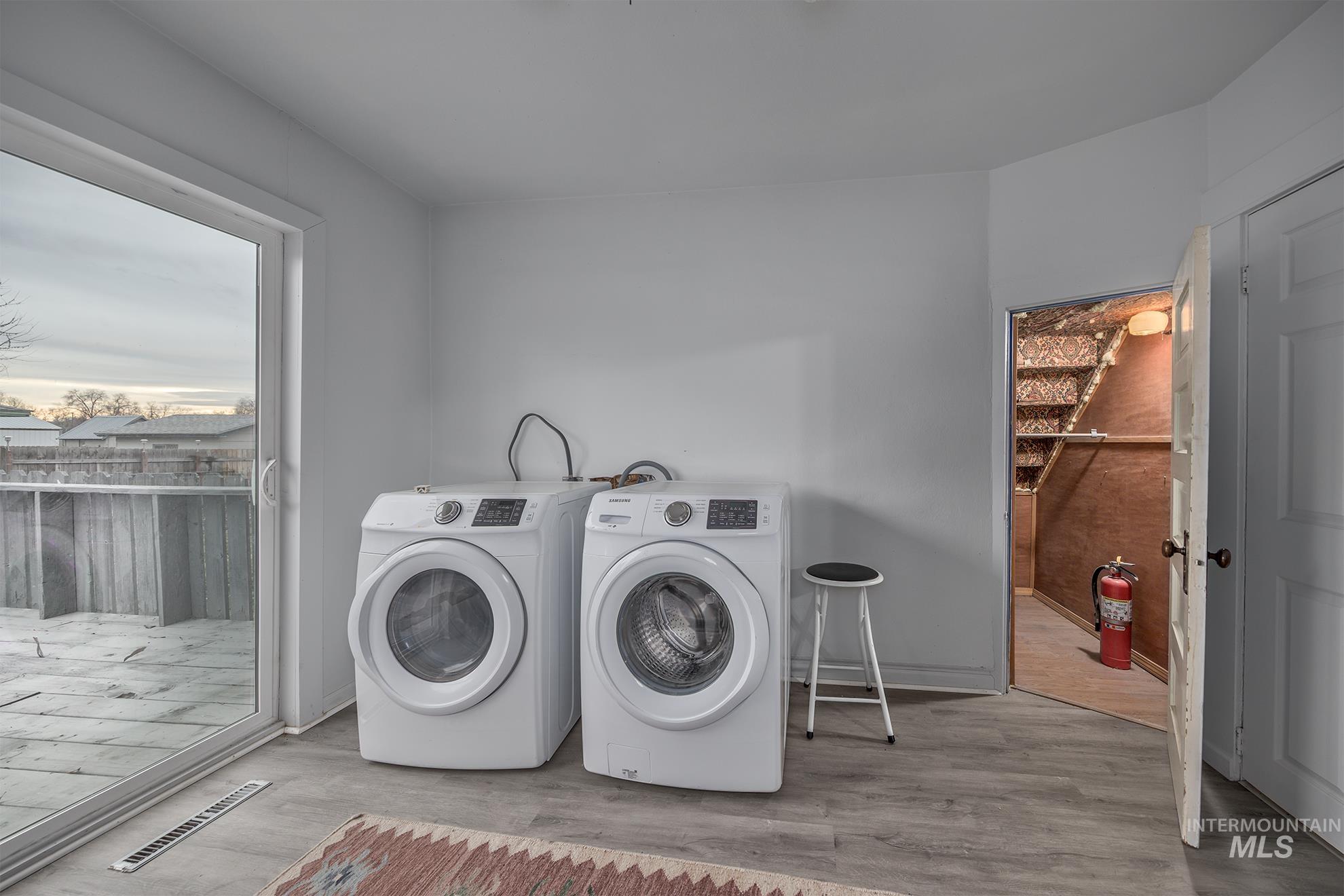 Laundry room with wood finished floors and independent washer and dryer