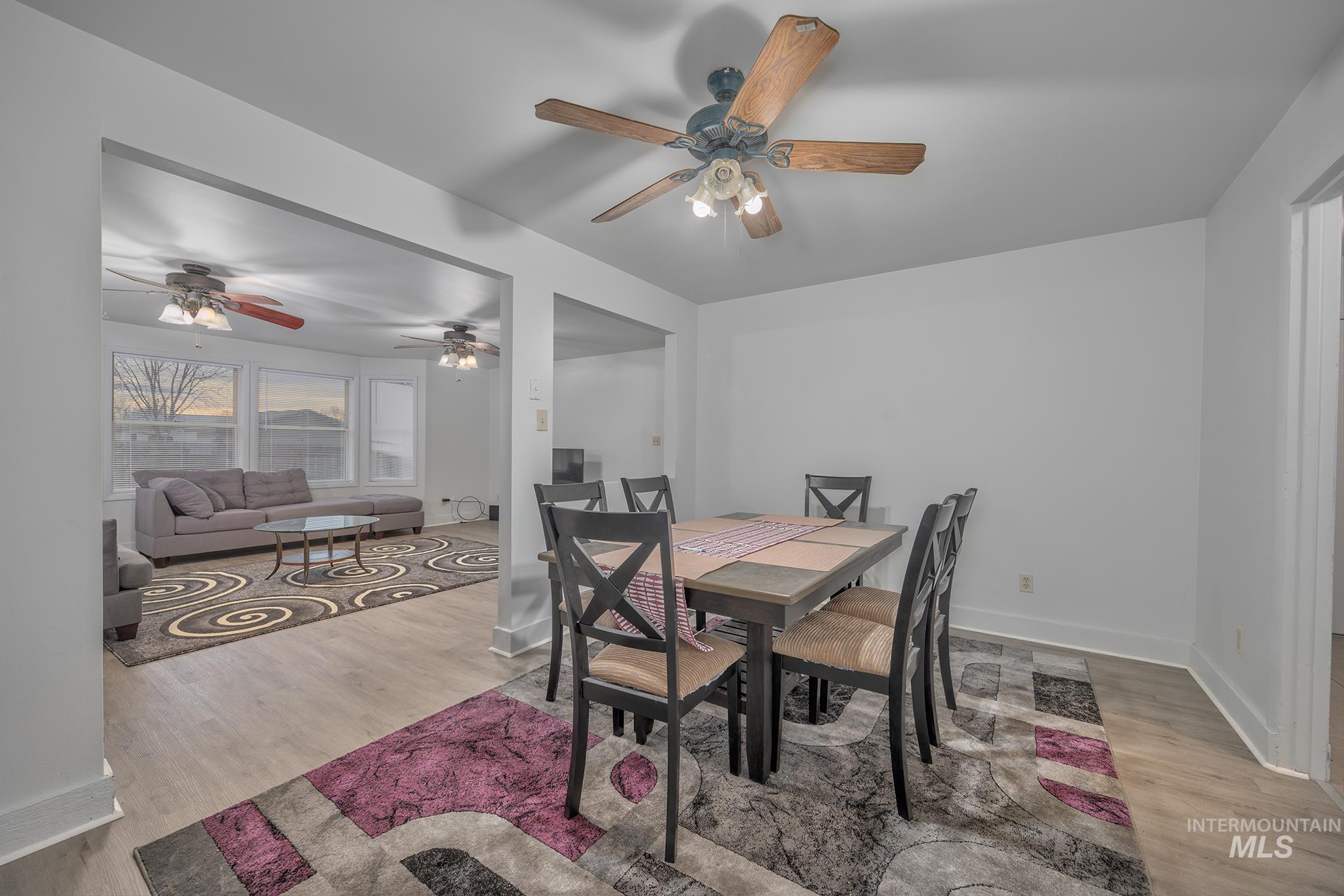 Dining area with light wood-style flooring and a ceiling fan
