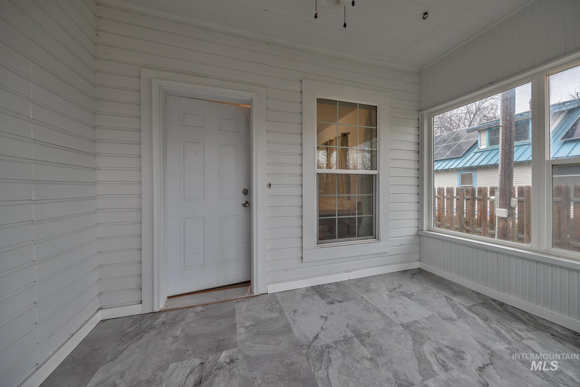 Unfurnished sunroom featuring a ceiling fan