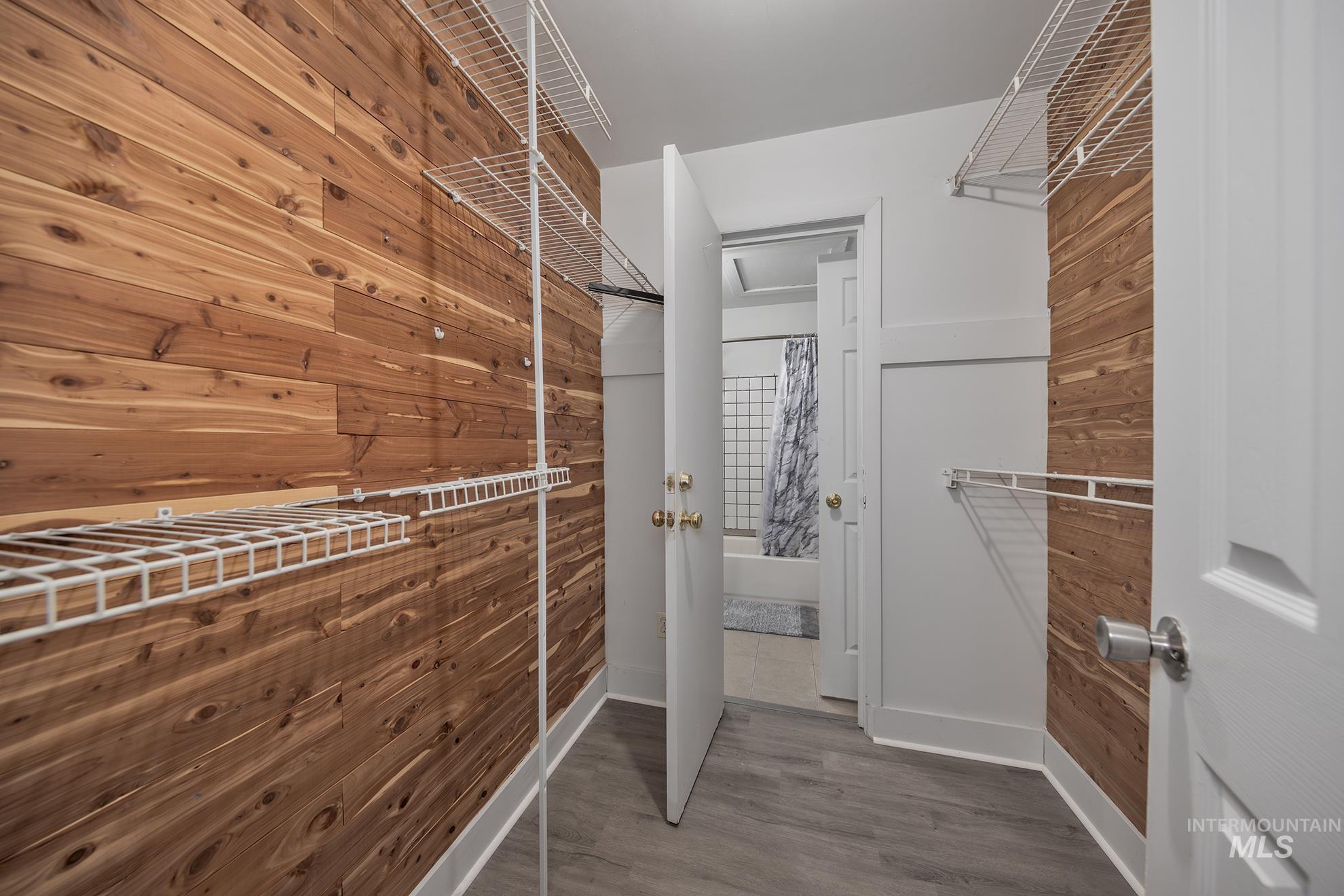 Walk in closet with wood finished floors