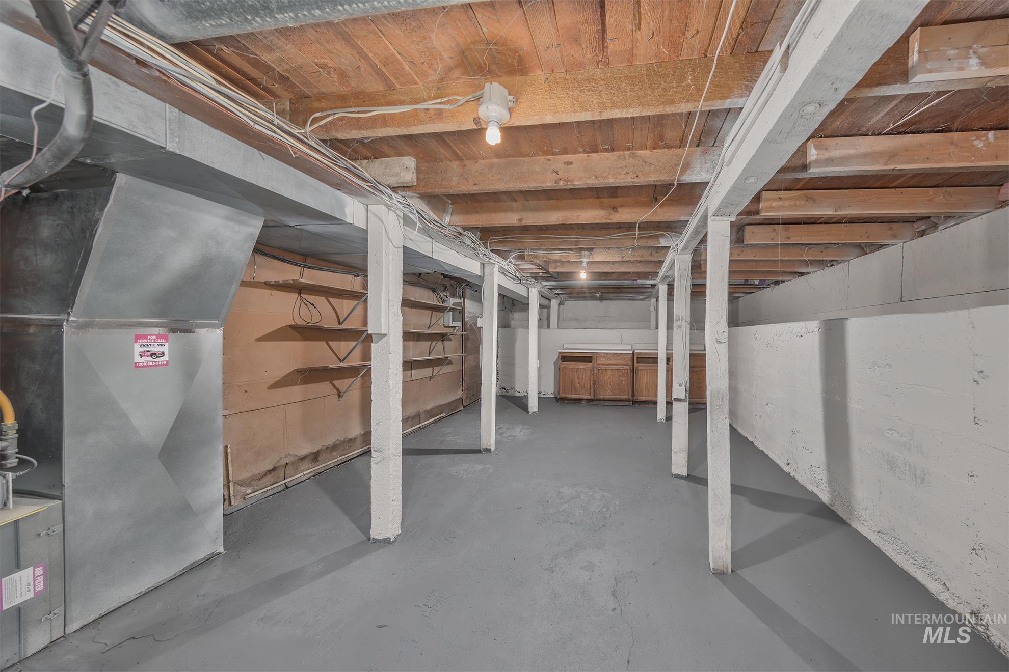 Unfinished below grade area featuring heating unit