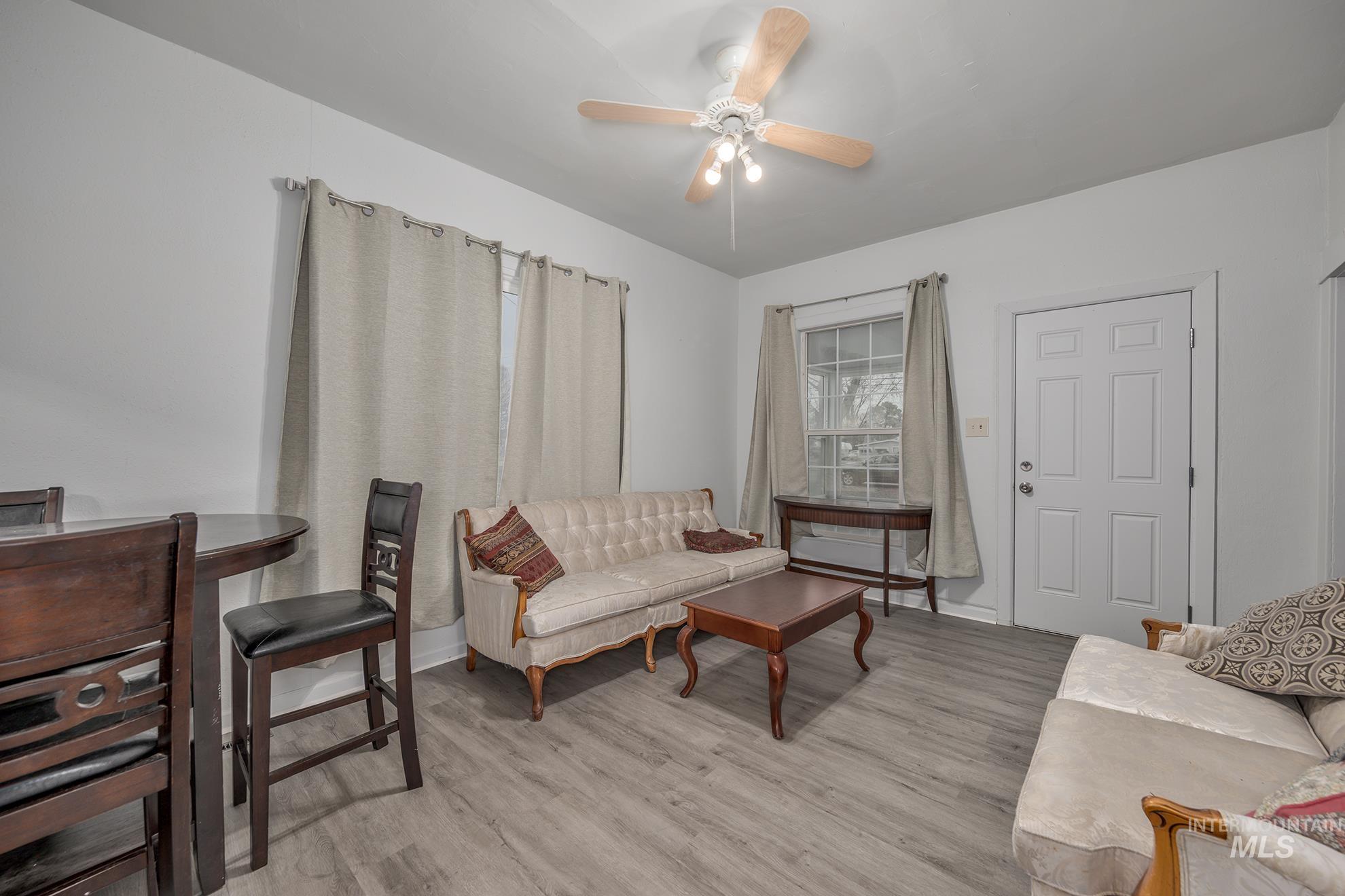 Living room with light wood-style floors and a ceiling fan